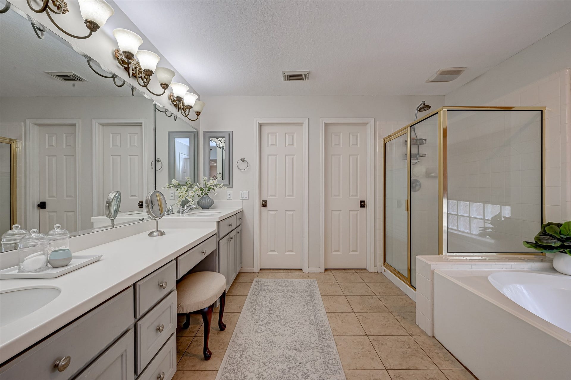 7707 Stone Arbor Drive, Sugar Land, TX 77479 Spacious ensuite primary bath offers plenty of room for two to get ready! An extra-long vanity provides 2 sinks, abundant cabinetry & generous counter space, while the wall-to-wall mirror visually expands the room. A separate shower and jetted tub complete the bathing area, while 2 separate walk-in closets provide his-and-hers storage.