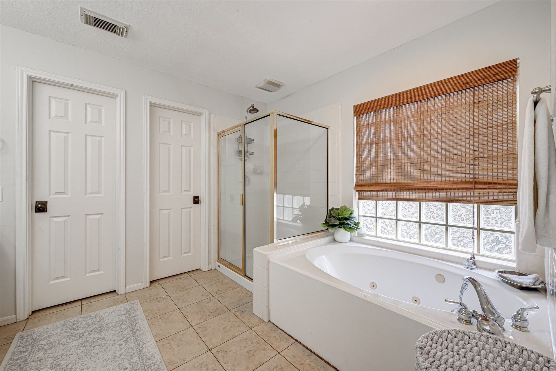 7707 Stone Arbor Drive, Sugar Land, TX 77479 Soak or showerthe choice is yours! Relax in the deep jetted tub beneath a large glass-block window that brings in natural light while maintaining privacy. A separate tiled shower sits just alongside, creating a traditional executive-bath layout. Two separate walk-in closets are conveniently located nearby.