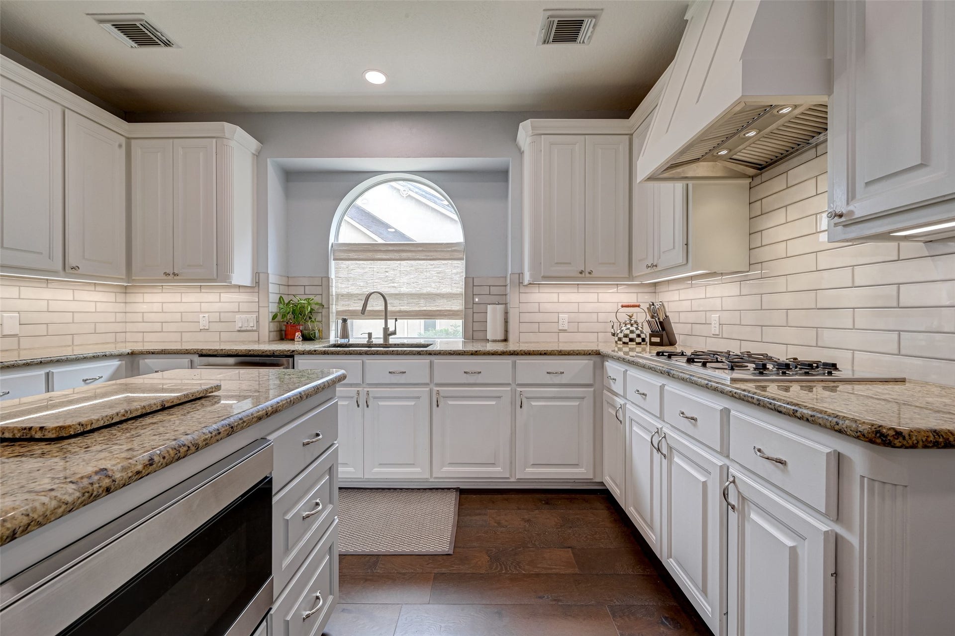 7707 Stone Arbor Drive, Sugar Land, TX 77479 For buyers who love to cook, here you go! The 4-burner gas cooktop is paired with a substantial vent hood (2023) and surrounded by generous prep space. Subway tile backsplash, under-cabinet lighting, granite counters, and abundant cabinetry combine classic style with everyday practicality.