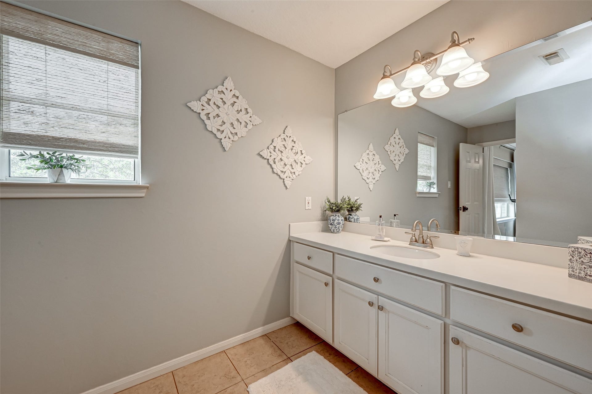 7707 Stone Arbor Drive, Sugar Land, TX 77479 A Jack & Jill bath designed for sharing! Bedroom #2 enjoys its own private sink vanity with generous counter space, cabinetry, large wall mirror & natural light. A linen closet provides additional storage, while the separate vanity arrangement gives each bedroom its own getting-ready space while sharing only the central bathing area.