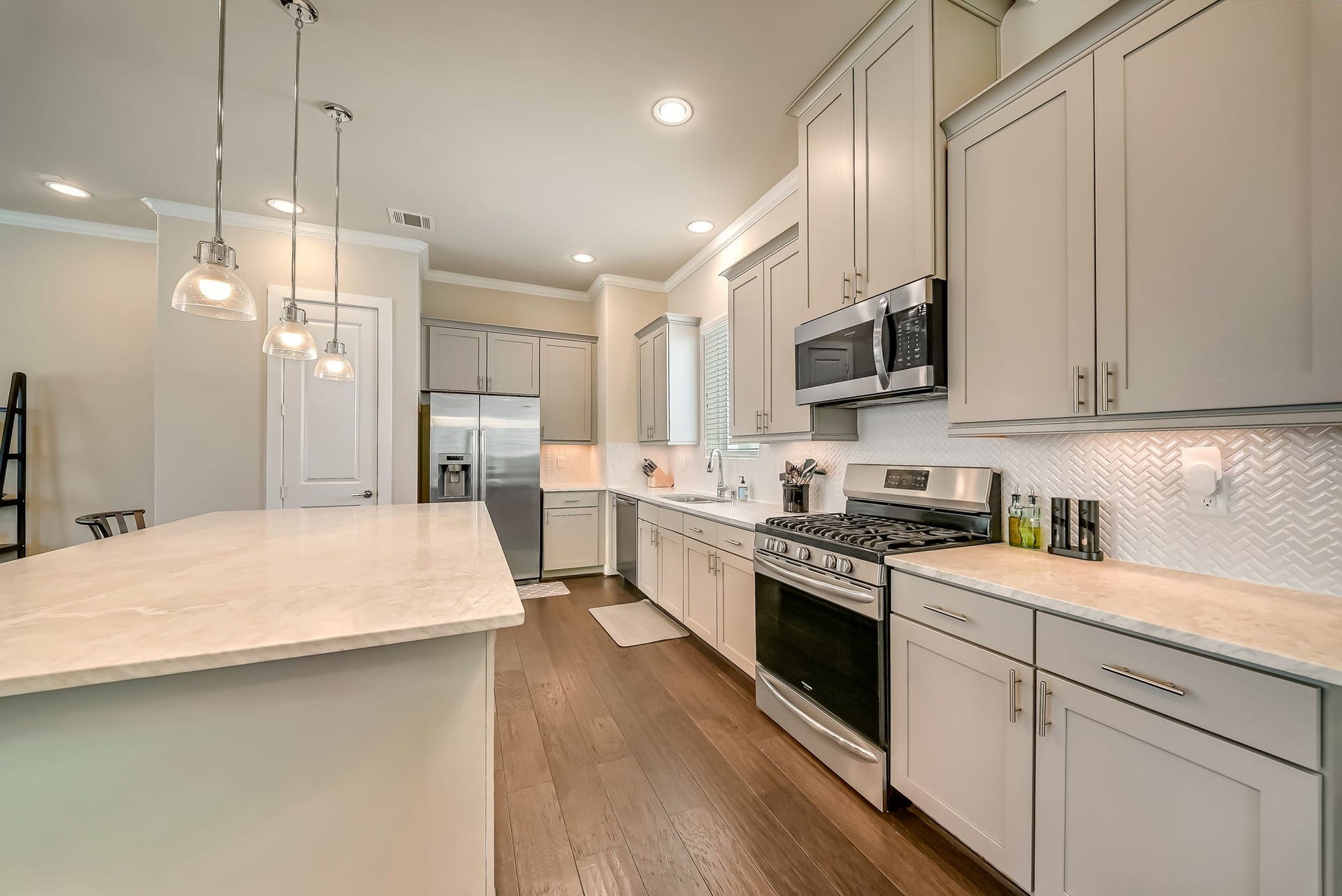 5916 Petty Street, #A, Houston, TX 77007 Gourmet kitchen with extensive prep space, under-cabinet lighting, deep sink, five-burner gas cooktop, and abundant storage.