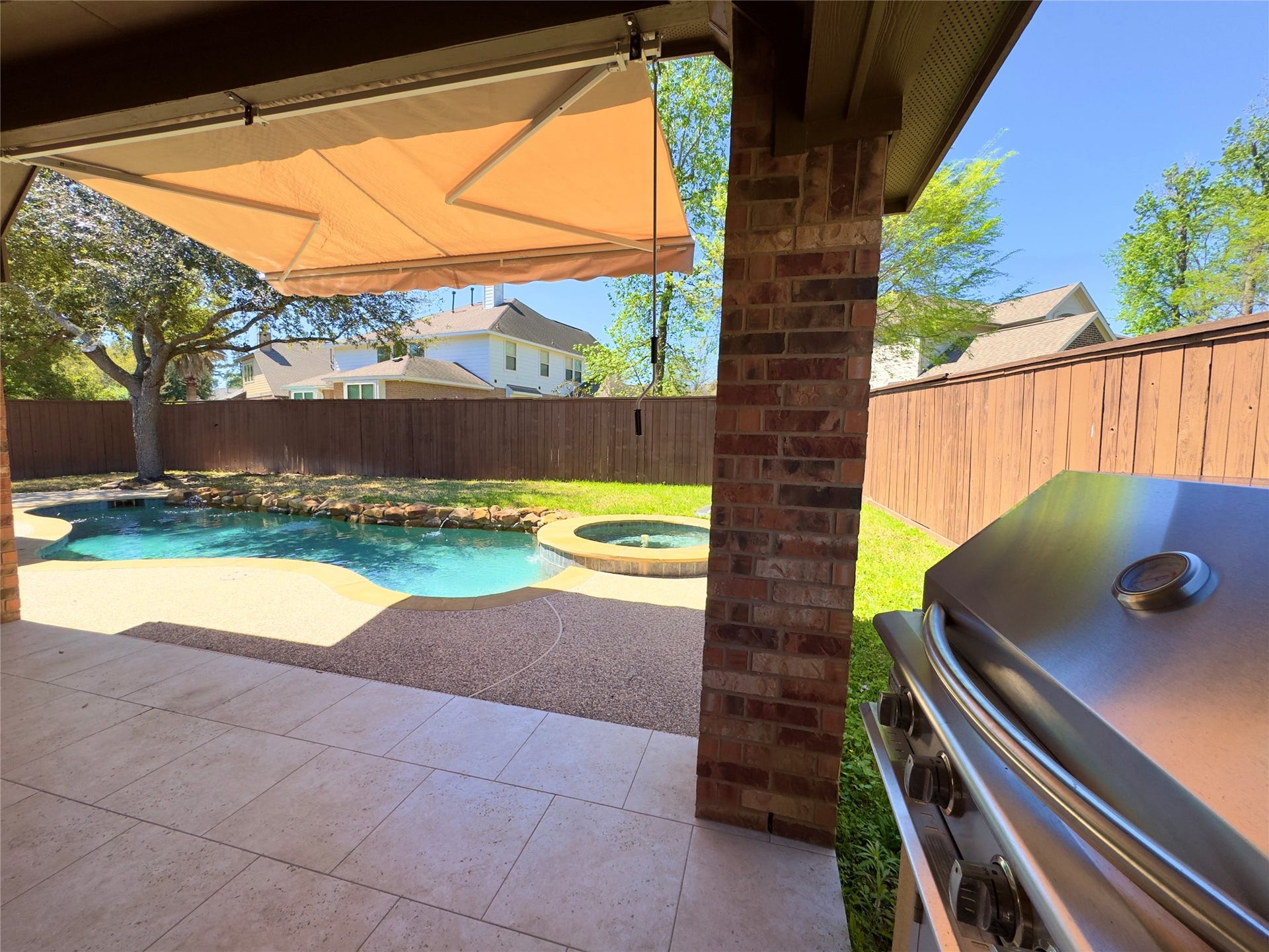 179 Hearthshire Circle, The Woodlands, TX 77354 Back patio with a grill and a retractable awning