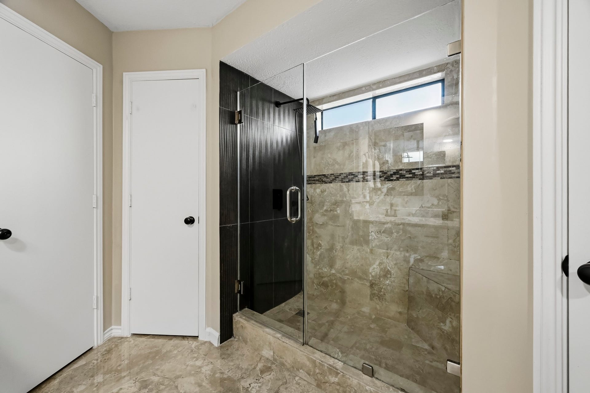 6714 Brittany Park Lane, Houston, TX 77066 Elegant bathroom featuring a spacious glass-enclosed shower with modern tile work and ample natural light.