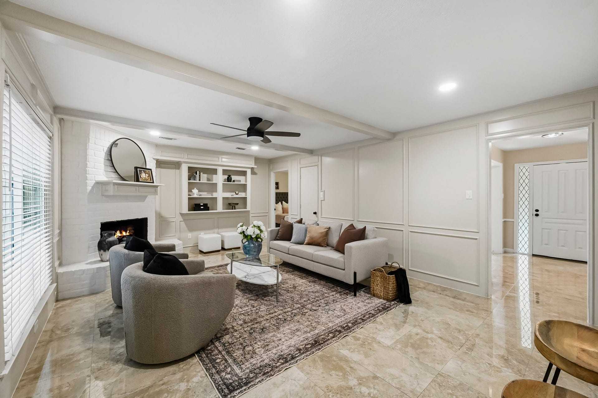 6714 Brittany Park Lane, Houston, TX 77066 Elegant living room with a cozy fireplace, stylish built-in shelves, and modern dcor, perfect for relaxing or entertaining.