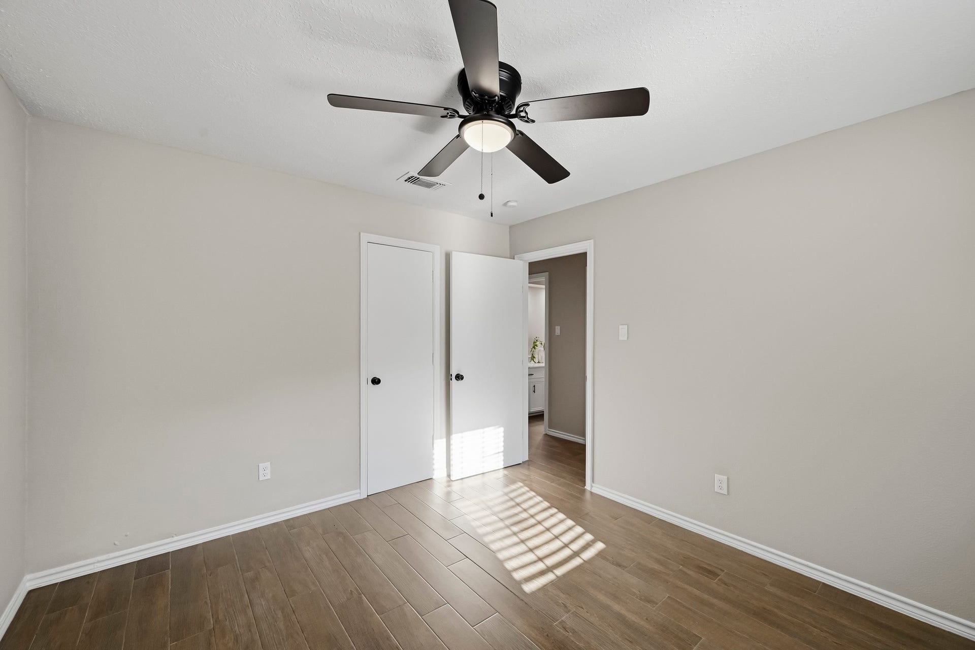 6714 Brittany Park Lane, Houston, TX 77066 Bright and inviting room featuring elegant wood flooring, a modern ceiling fan, and neutral wall tones, offering a versatile space for any decor style.