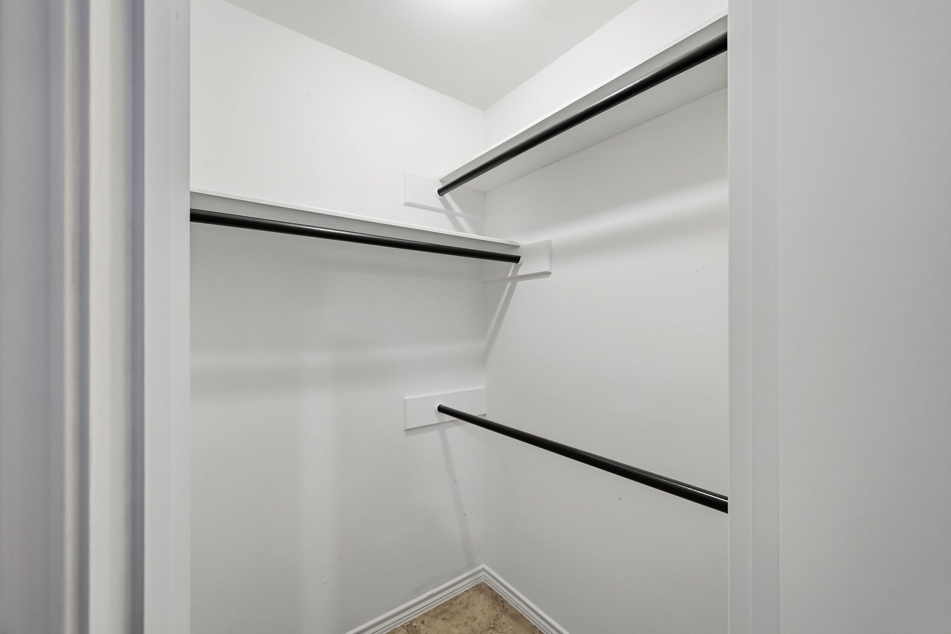6714 Brittany Park Lane, Houston, TX 77066 Spacious walk-in closet with multiple hanging rods and bright lighting, perfect for organizing clothing and accessories.