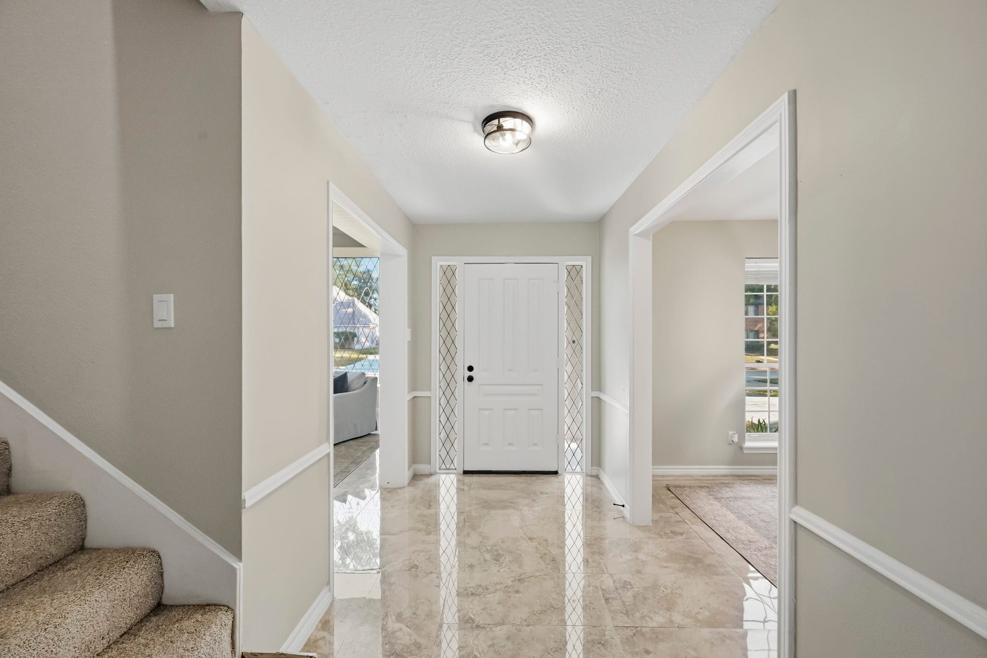 6714 Brittany Park Lane, Houston, TX 77066 Bright and inviting entryway with glossy tile flooring and neutral walls, flanked by open doorways leading to spacious living areas, offering a warm welcome to your home.