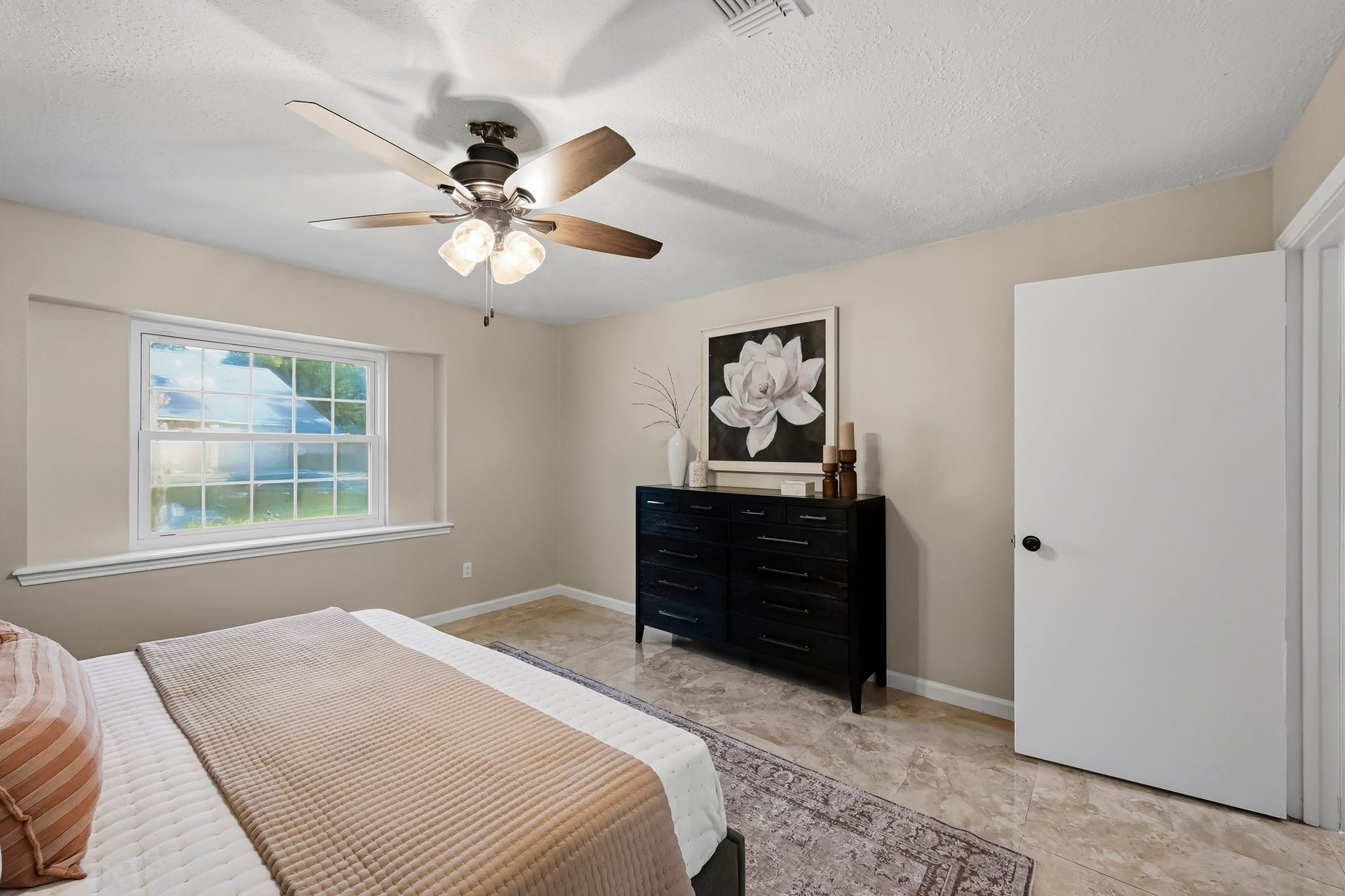6714 Brittany Park Lane, Houston, TX 77066 Cozy bedroom featuring a large window that fills the space with natural light, complemented by neutral walls and a ceiling fan for comfort.