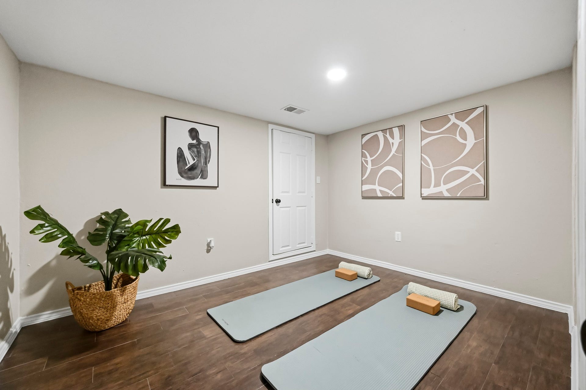 6714 Brittany Park Lane, Houston, TX 77066 Cozy and inviting exercise room featuring elegant wood flooring, soft lighting, and stylish wall art, perfect for yoga or meditation.