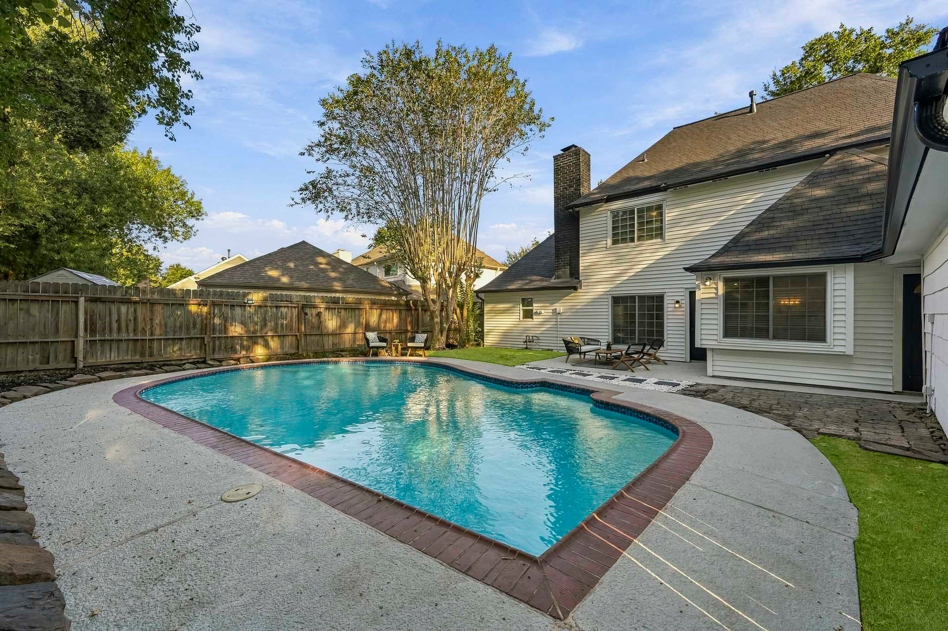 6714 Brittany Park Lane, Houston, TX 77066 Charming backyard oasis with a sparkling in-ground pool, surrounded by lush greenery and a spacious patio perfect for outdoor relaxation and entertaining.