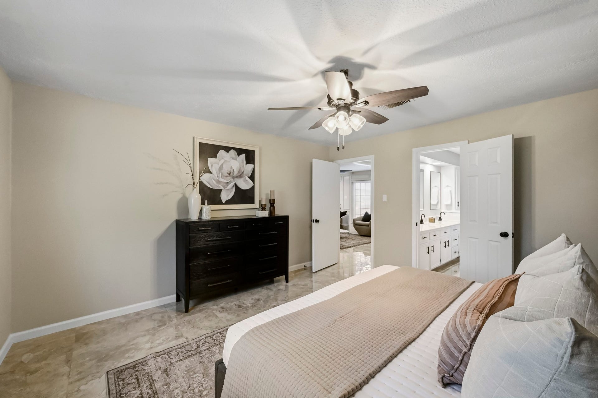 6714 Brittany Park Lane, Houston, TX 77066 Elegant bedroom featuring a neutral palette with a ceiling fan, spacious layout, and an en-suite bathroom.