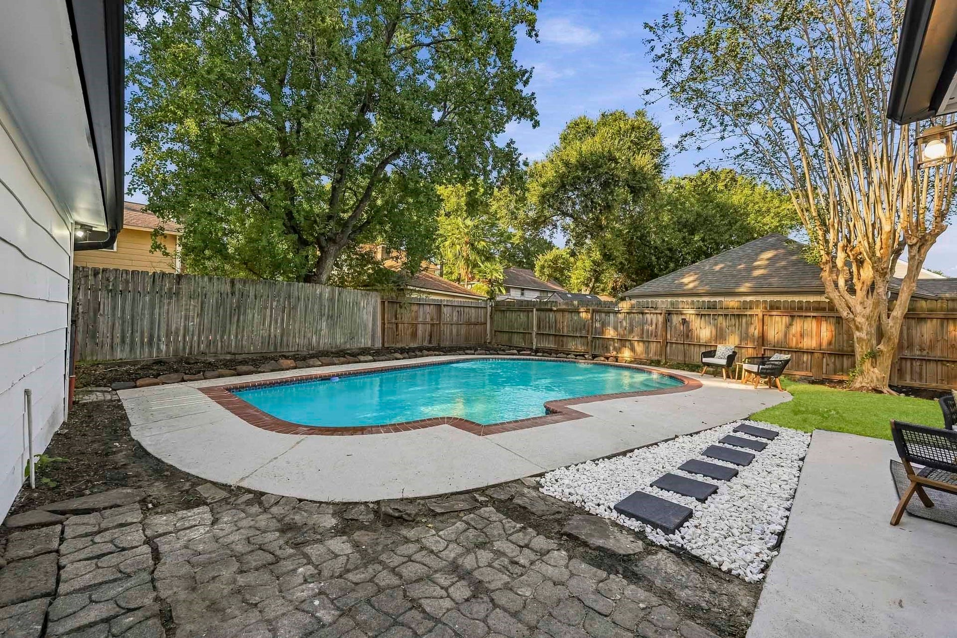 6714 Brittany Park Lane, Houston, TX 77066 Enjoy a refreshing retreat in this spacious backyard featuring a sparkling pool, surrounded by a privacy fence and lush greenery.