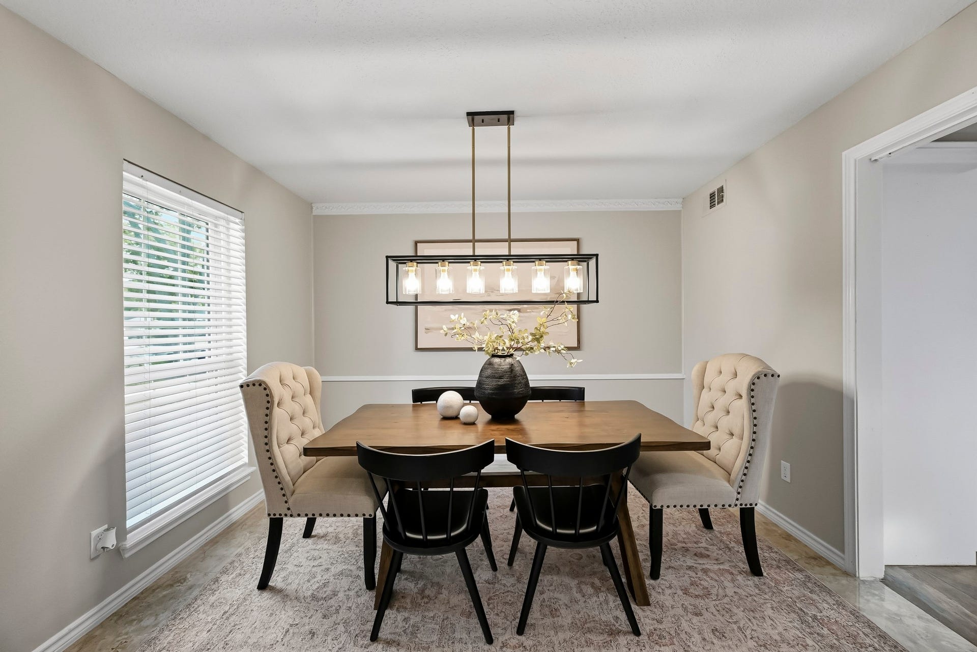 6714 Brittany Park Lane, Houston, TX 77066 Elegant dining room featuring a stylish chandelier, a wooden table with seating for six, and plush upholstered chairs, accented by soft natural light from a large window.
