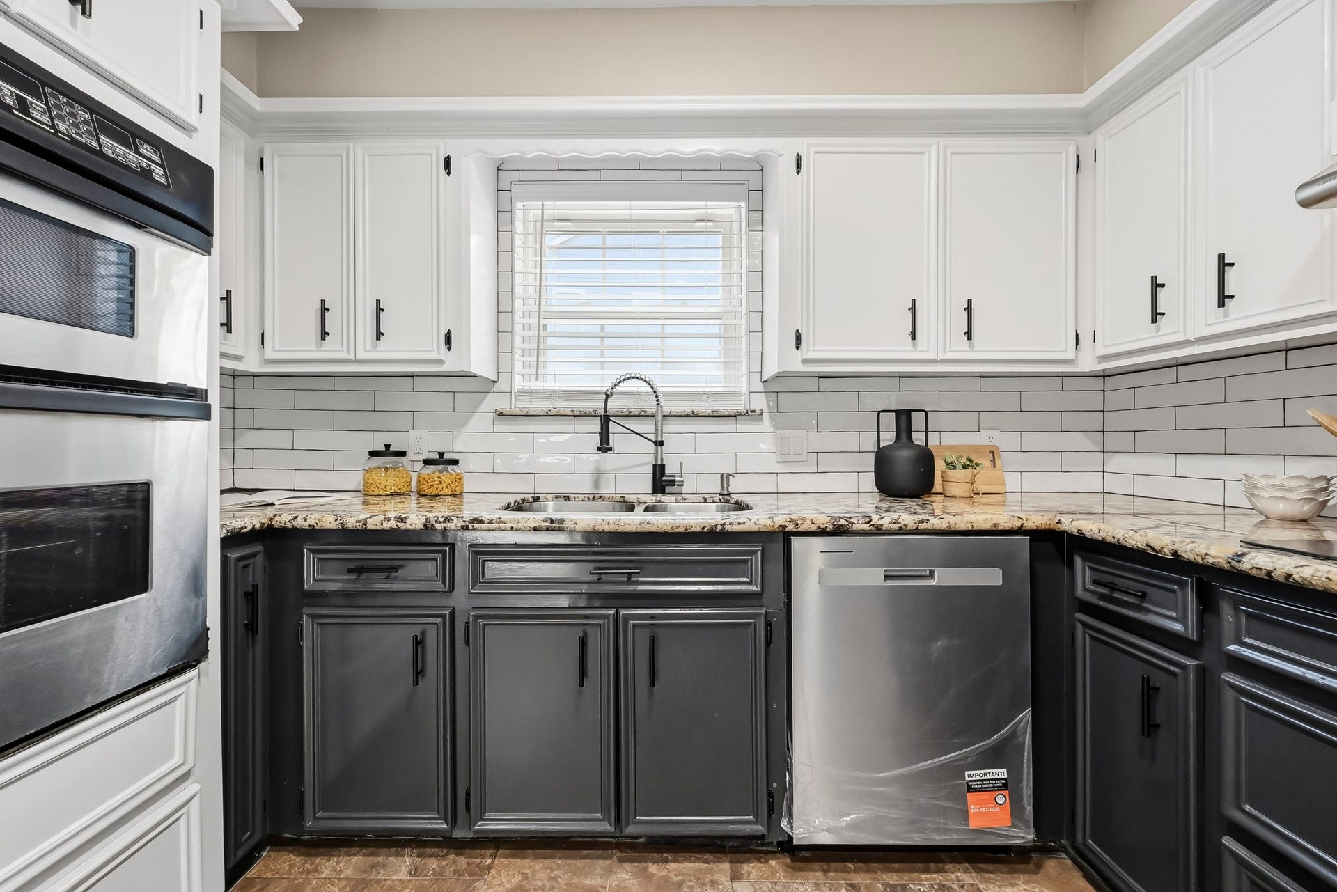 6714 Brittany Park Lane, Houston, TX 77066 Charming kitchen with a sleek black and white color scheme, featuring granite countertops, stainless steel appliances, and ample cabinet space.