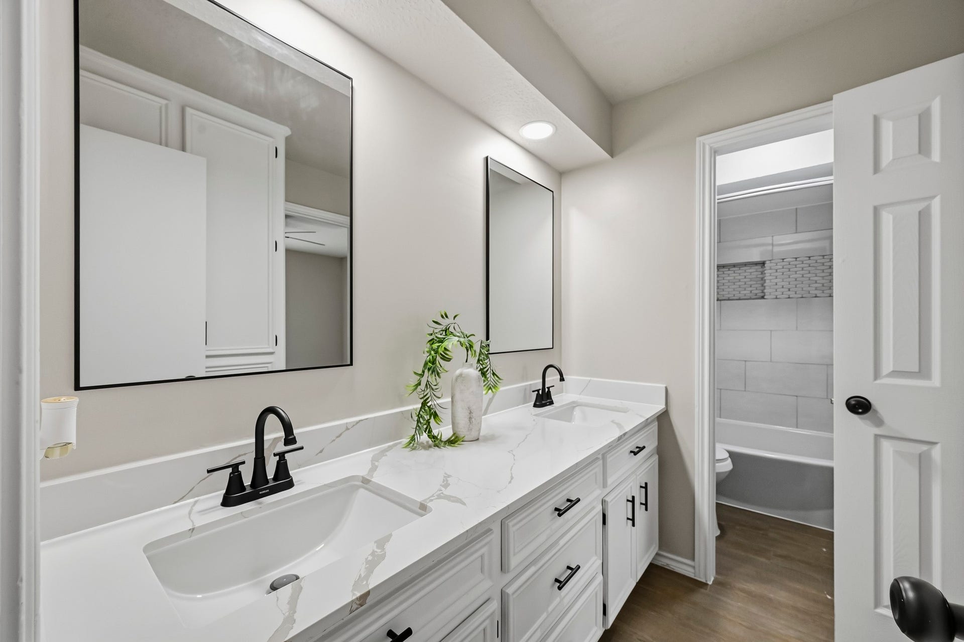 6714 Brittany Park Lane, Houston, TX 77066 Modern bathroom featuring a sleek double vanity with marble countertops, stylish black fixtures, and ample cabinet space.