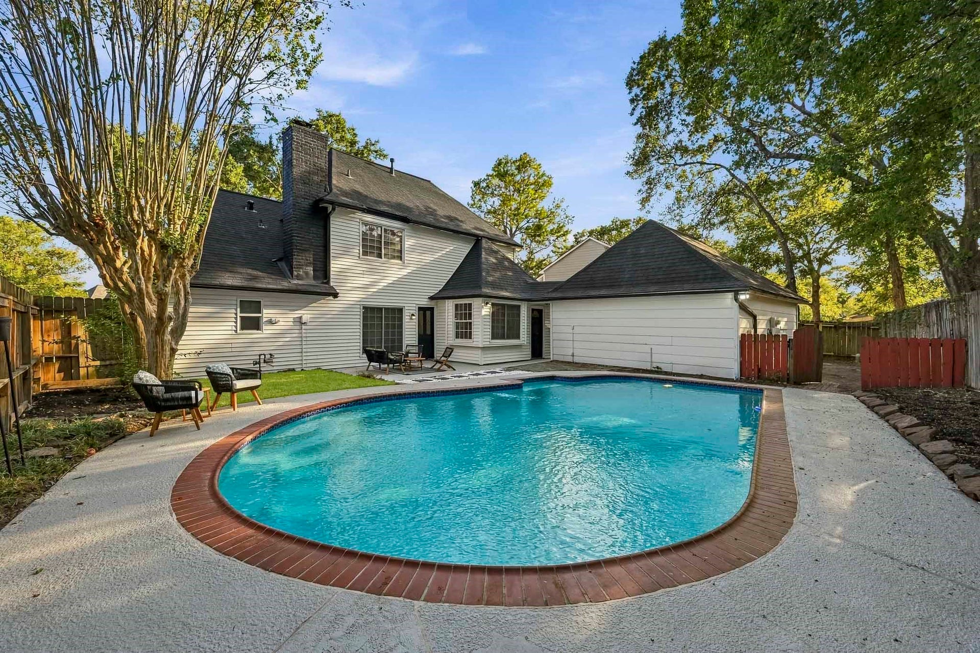 6714 Brittany Park Lane, Houston, TX 77066 Inviting backyard oasis with a sparkling pool, surrounded by mature trees and ample patio space for relaxation and entertainment.