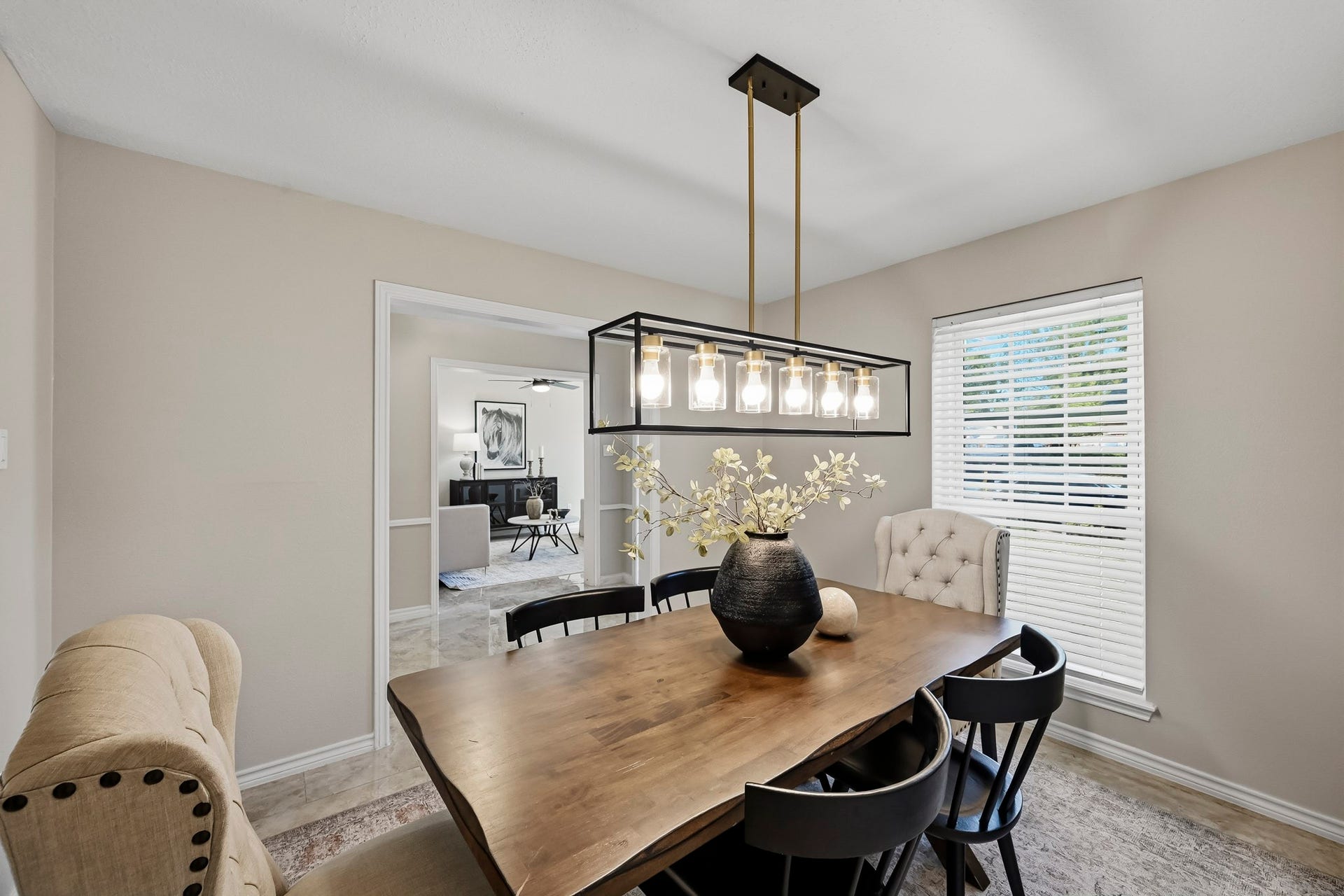 6714 Brittany Park Lane, Houston, TX 77066 Elegant dining room featuring a wooden table, modern chandelier, and natural light from a large window, creating a cozy and inviting atmosphere.