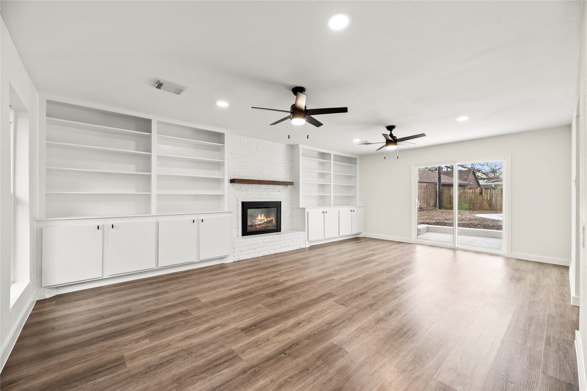 12551 Honeywood Trail, Houston, TX 77077 Spacious family room with LVP flooring, custom built-ins and a cozy fireplace.