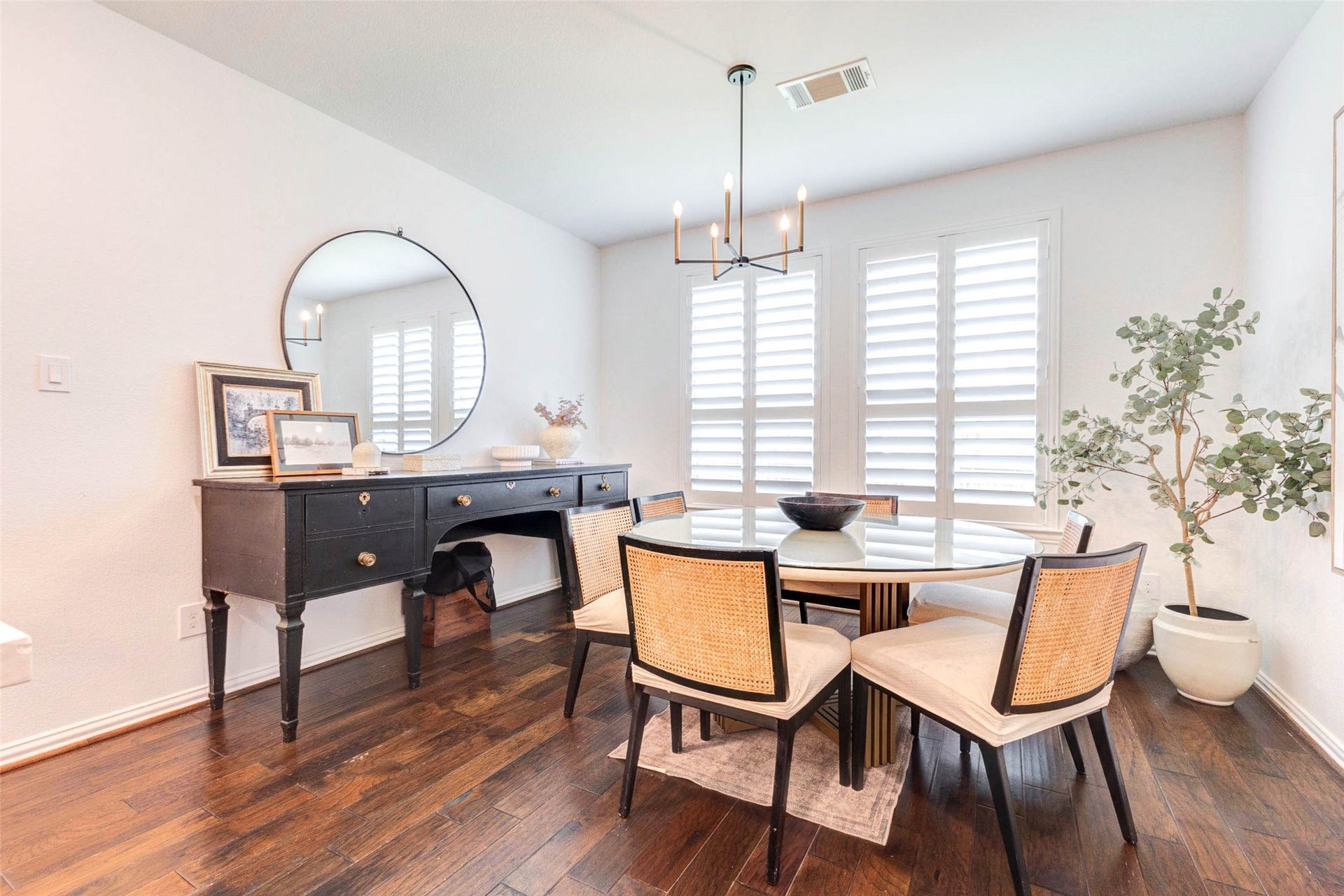 A bright and inviting dining space offers the perfect setting for everyday meals or special occasions. Surrounded by windows with plantation shutters, the room is filled with soft natural light. A stylish light fixture adds a modern touch, while the layout provides ample space for gatherings. This dining area blends comfort and elegance, with room for everyday meals and entertaining.