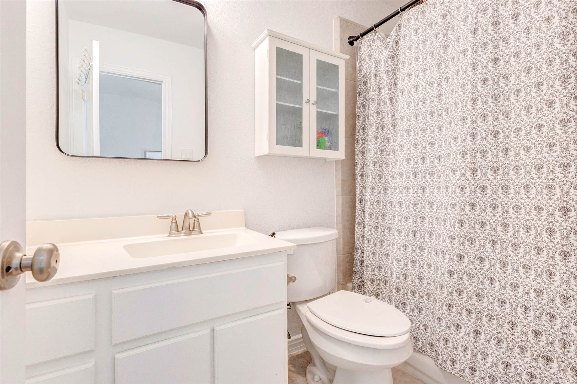 Bright and functional, this secondary bathroom offers a clean design with a spacious vanity and ample storage. The large mirror reflects light beautifully, enhancing the room's open feel. A shower and tub combination provides versatility, while neutral tones create a timeless look. This bathroom is designed for everyday convenience.