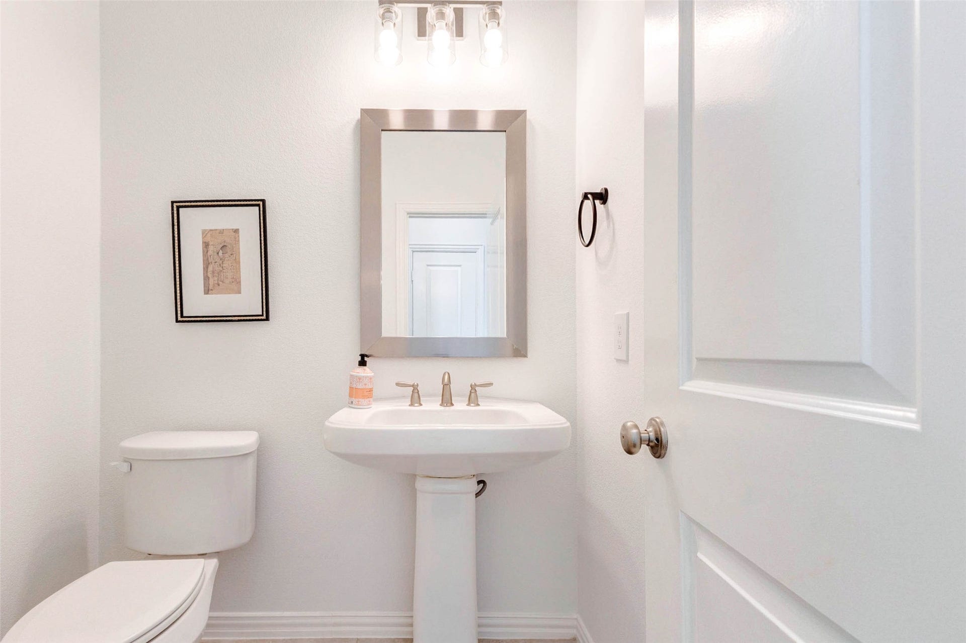 This conveniently located powder bath offers a clean and polished design with a pedestal sink and classic finishes. Bright lighting and a neutral color scheme create a fresh, welcoming feel for guests. The compact layout maximizes functionality without sacrificing style, making it a perfect addition for entertaining and everyday convenience.