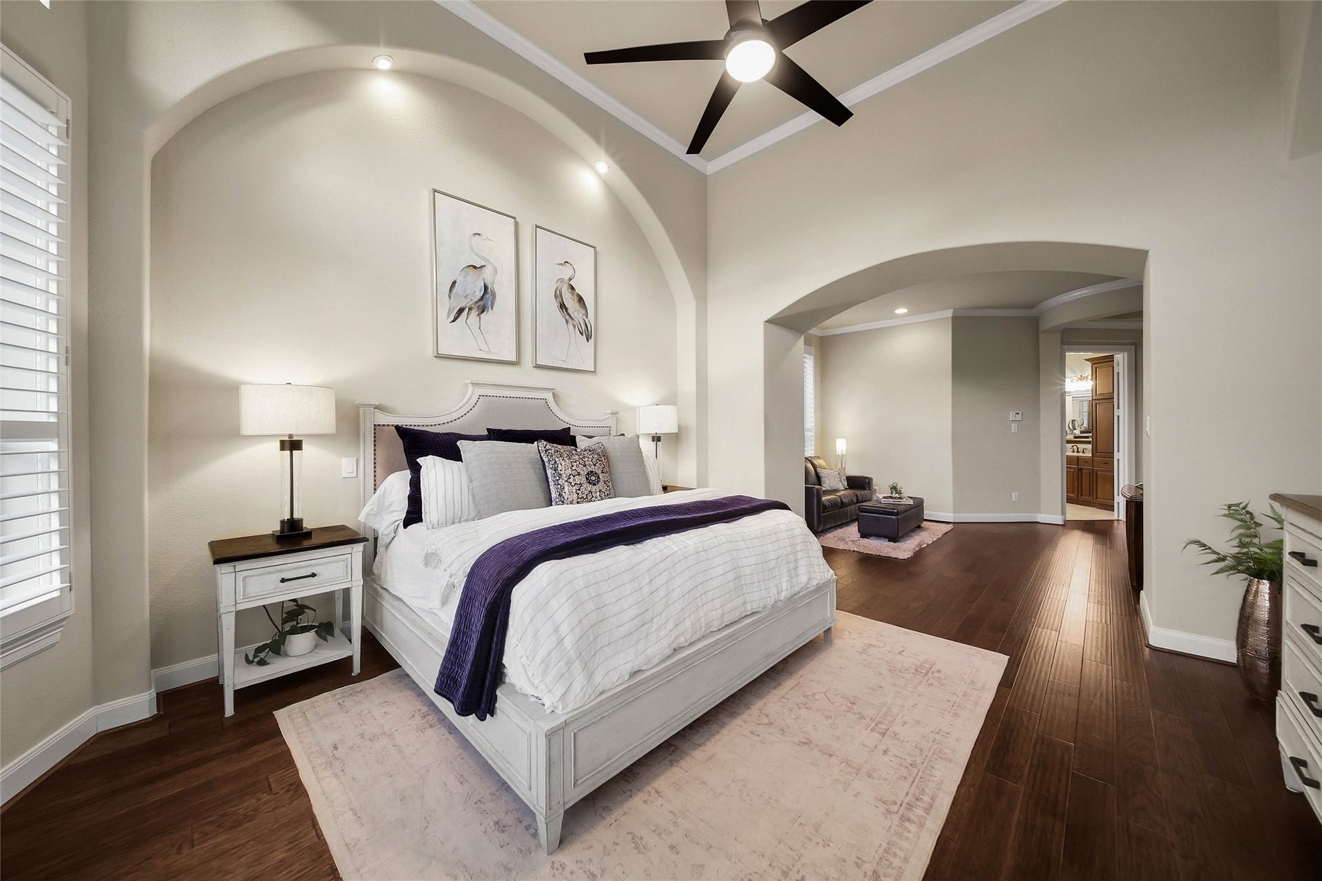 5318 Briarcliff Lane, Fulshear, TX 77441 Architectural arches, rich wood floors, built-in shelving, and classic shutters create a beautifully refined look in the primary bedroom, blending timeless elegance with thoughtful design.