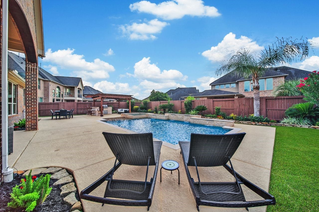 5318 Briarcliff Lane, Fulshear, TX 77441 Lush landscaping frames the backyard with natural beauty, creating a serene and picturesque setting to enjoy throughout the year. Three built-in umbrella holes around the pool decking provide convenient options for adding shade, keeping you cool and comfortable while enjoying the backyard oasis.
