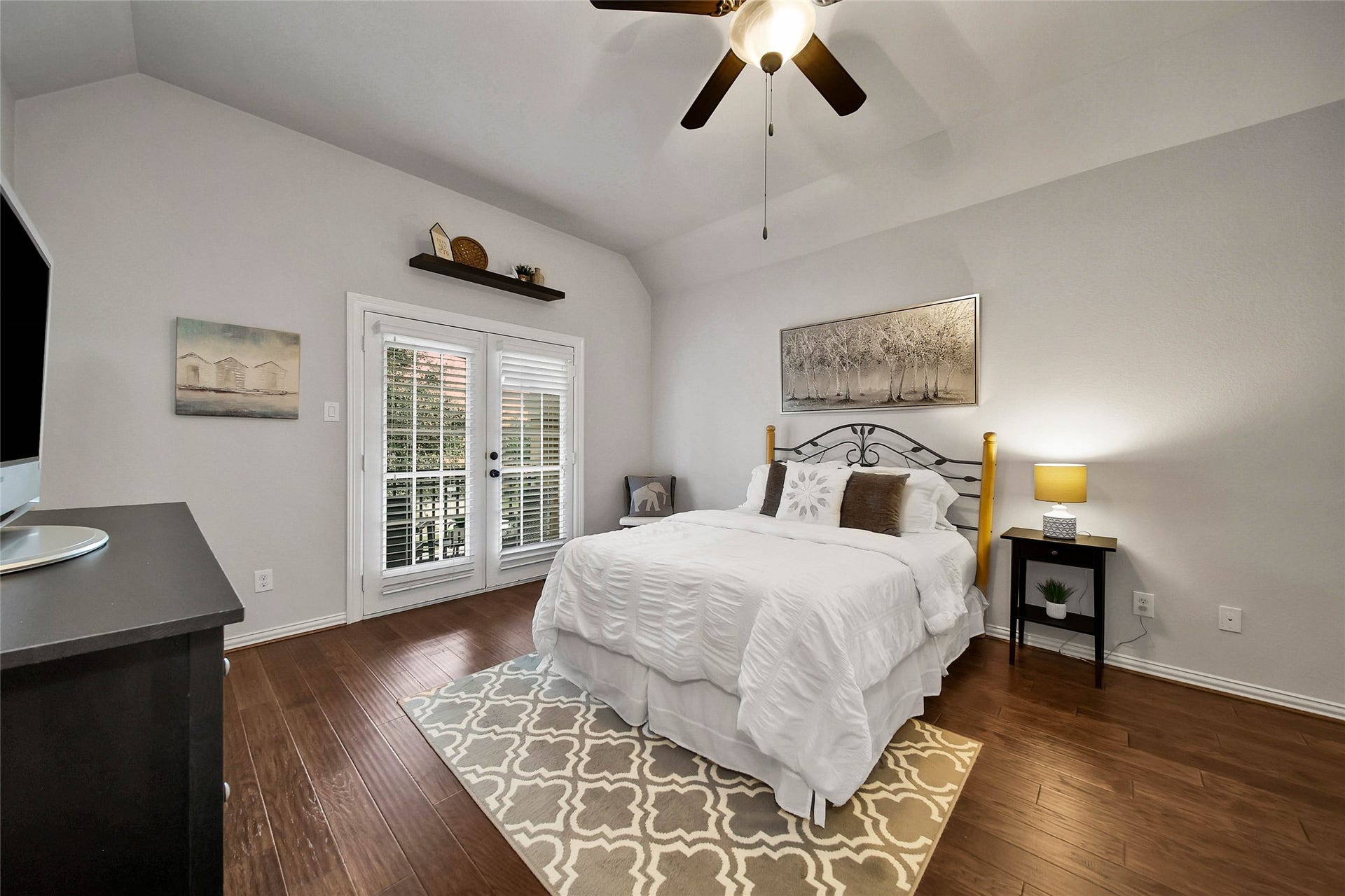 5318 Briarcliff Lane, Fulshear, TX 77441 The guest bedroom features a ceiling fan, walk-in closet, and private balcony, creating a comfortable retreat with its own outdoor escape.