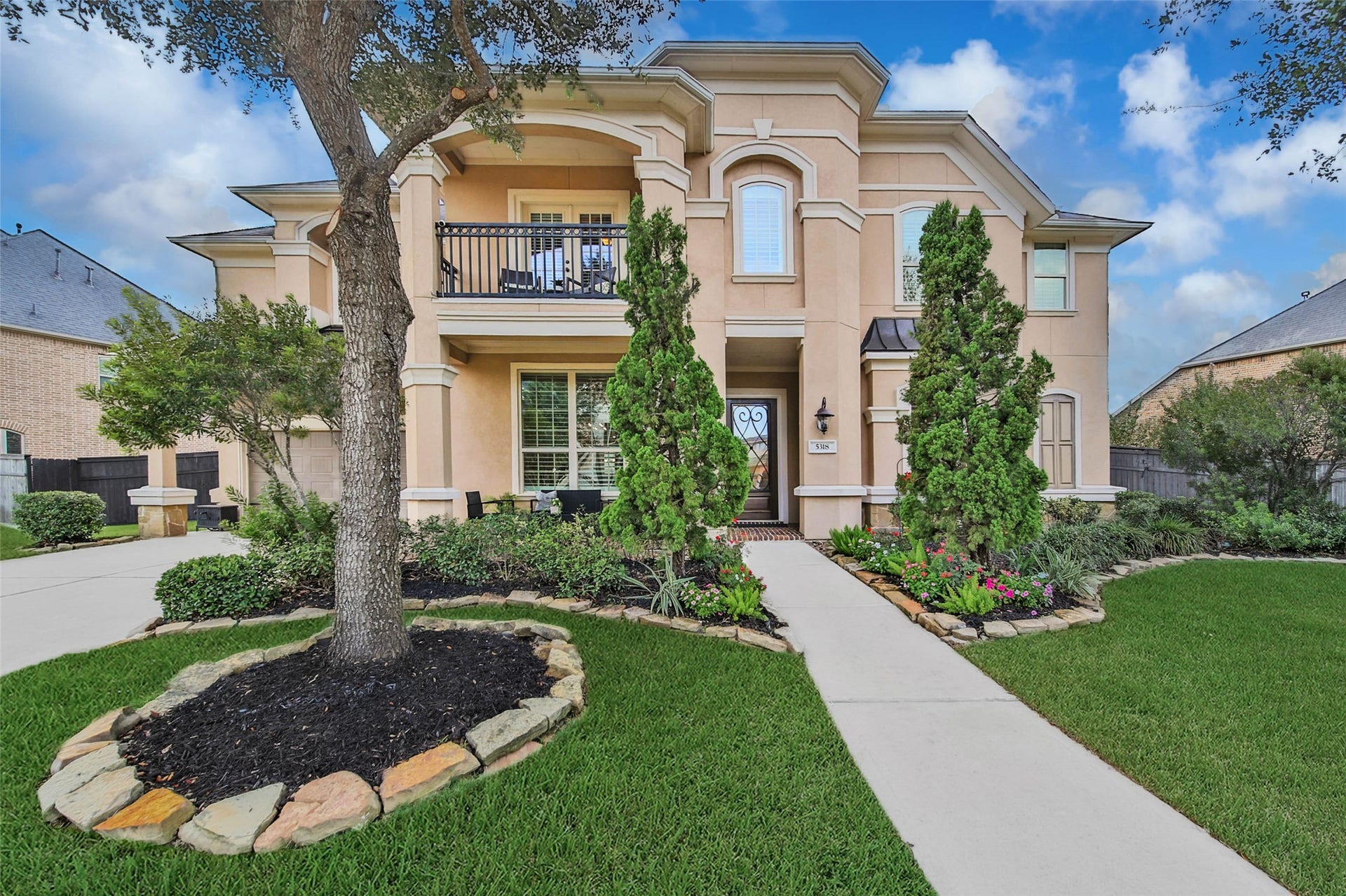 5318 Briarcliff Lane, Fulshear, TX 77441 The professionally landscaped yard, featuring mature shrubs, vibrant color, and fresh sod, creates striking curb appeal and a warm welcome for guests.