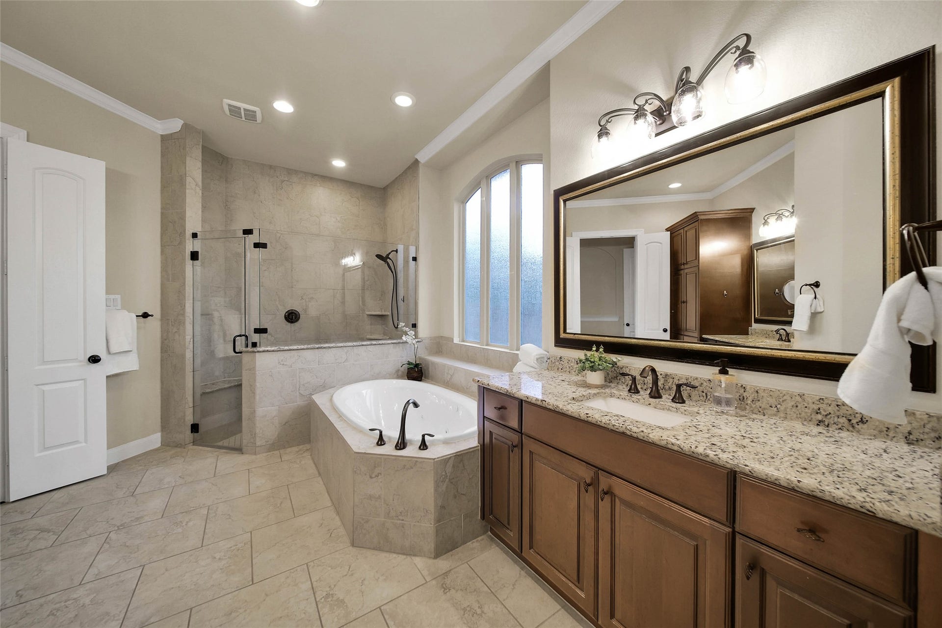 5318 Briarcliff Lane, Fulshear, TX 77441 The spacious primary bath features a relaxing jetted tub, a frameless glass shower, and plenty of room for two to comfortably get ready for the day.