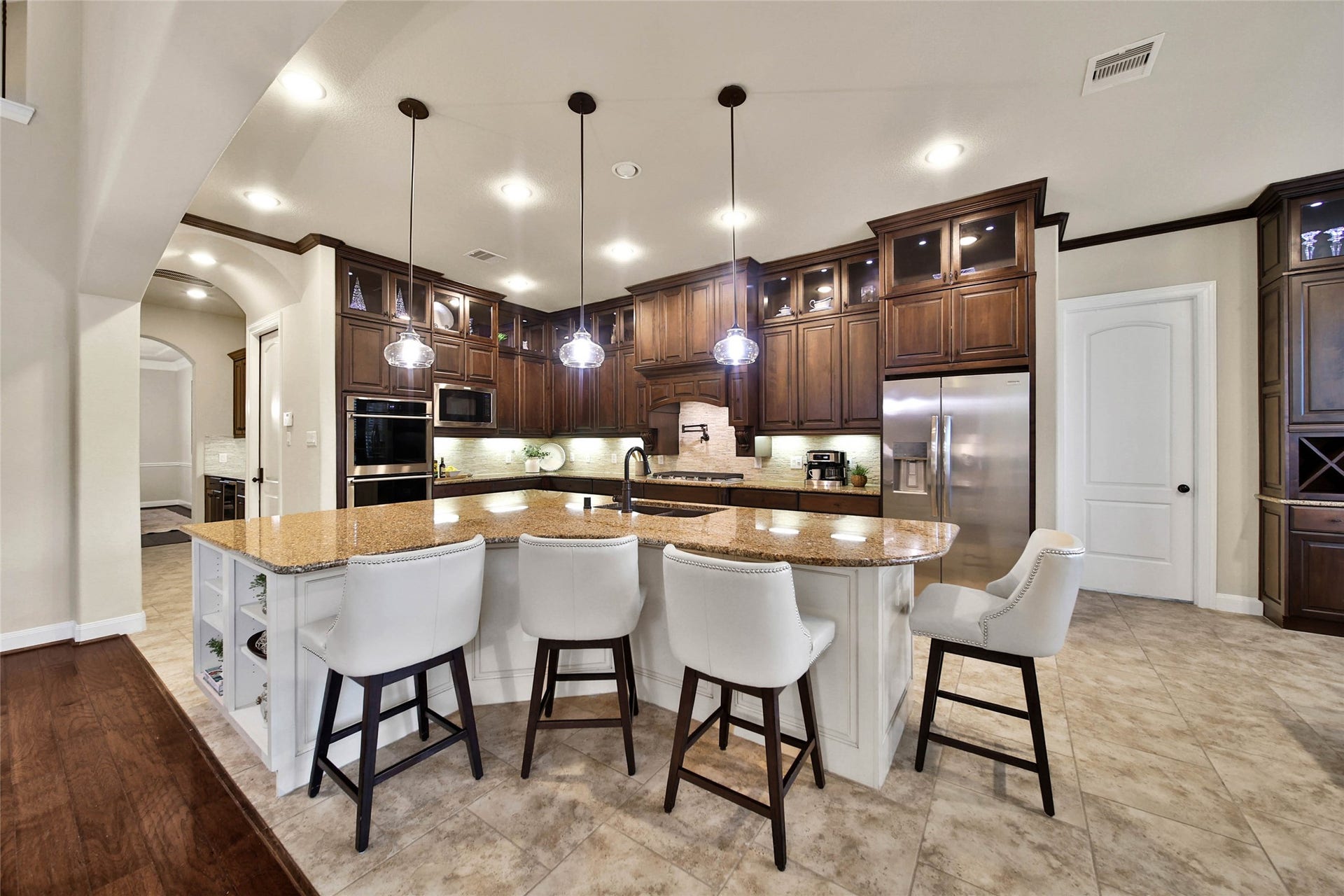 5318 Briarcliff Lane, Fulshear, TX 77441 Style meets function in this beautifully appointed kitchen that is sure to impress any chef! Abundant upgraded cabinetry provides exceptional storage, including elegant glass-front upper cabinets with puck lighting, while expansive countertops offer plenty of space for meal prep.