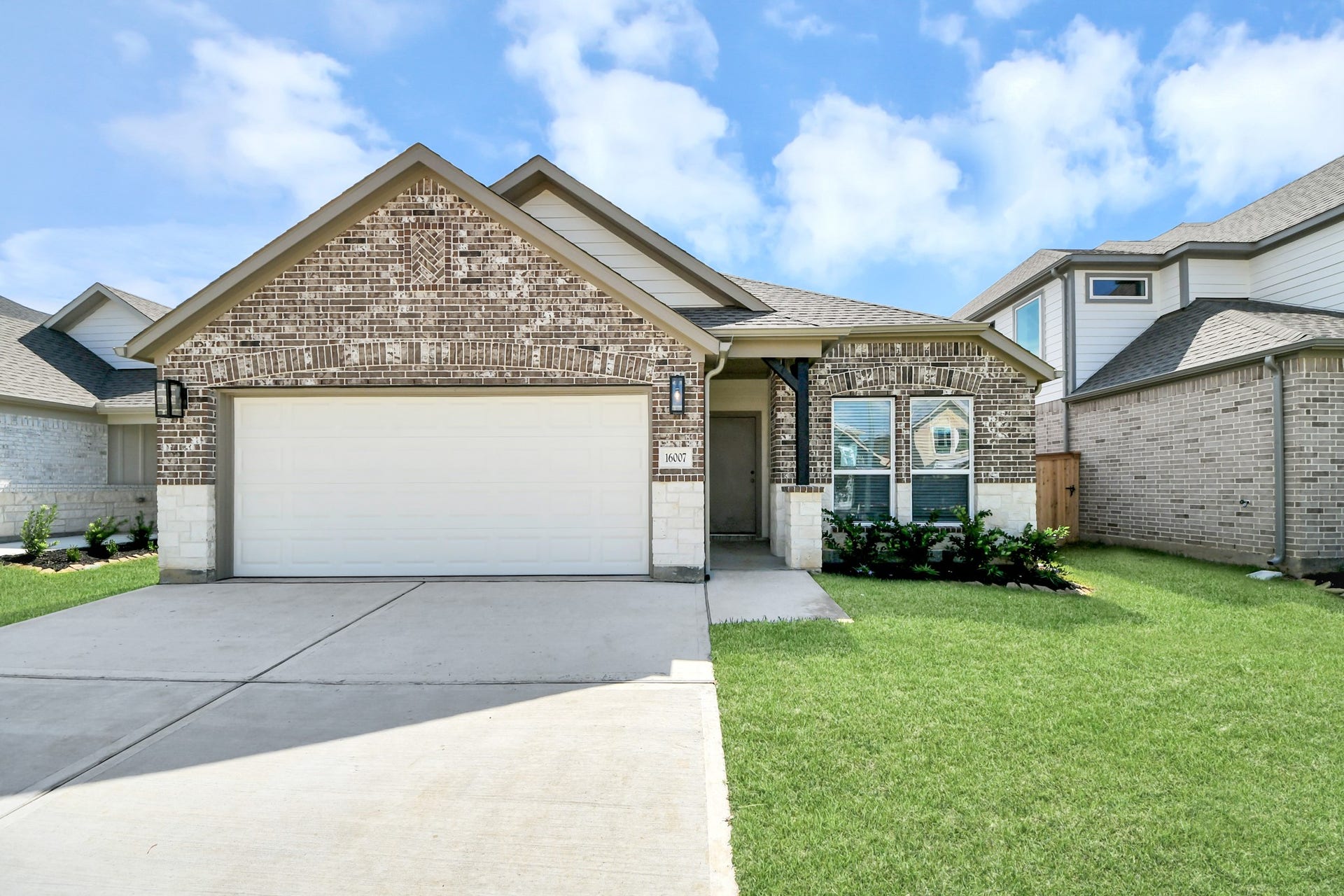 16007 Sycamore Maple Lane, Cypress, TX 77429 Meticulously maintained yard and lush landscape, paired with a premium elevation featuring captivating brick accents. Modern coach lights add a touch of contemporary elegance to the exterior.