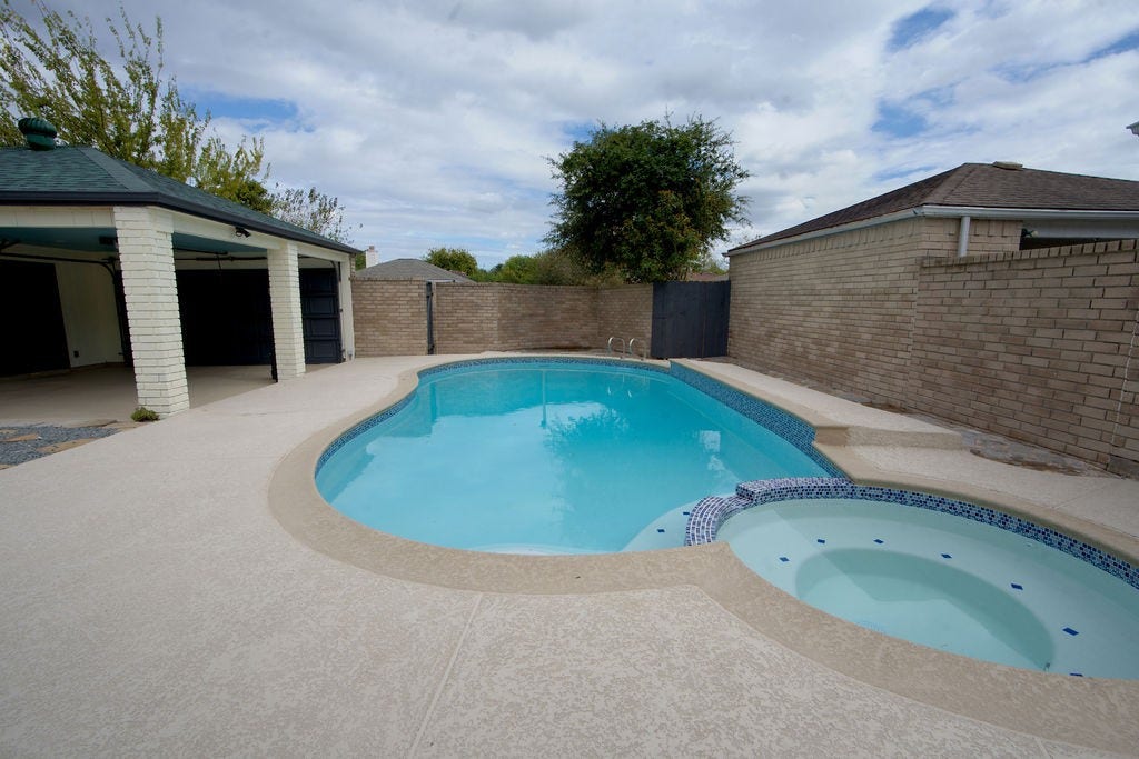 Enjoy the serene backyard oasis featuring a sparkling pool perfect for relaxation and entertaining.