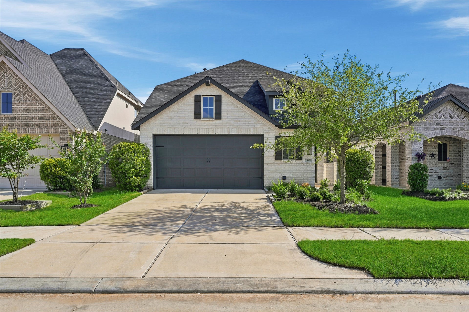 29821 Ellwood Lane, Fulshear, TX 77441 Classic brick exterior with manicured landscaping, a two-car garage, and inviting curb appeal.