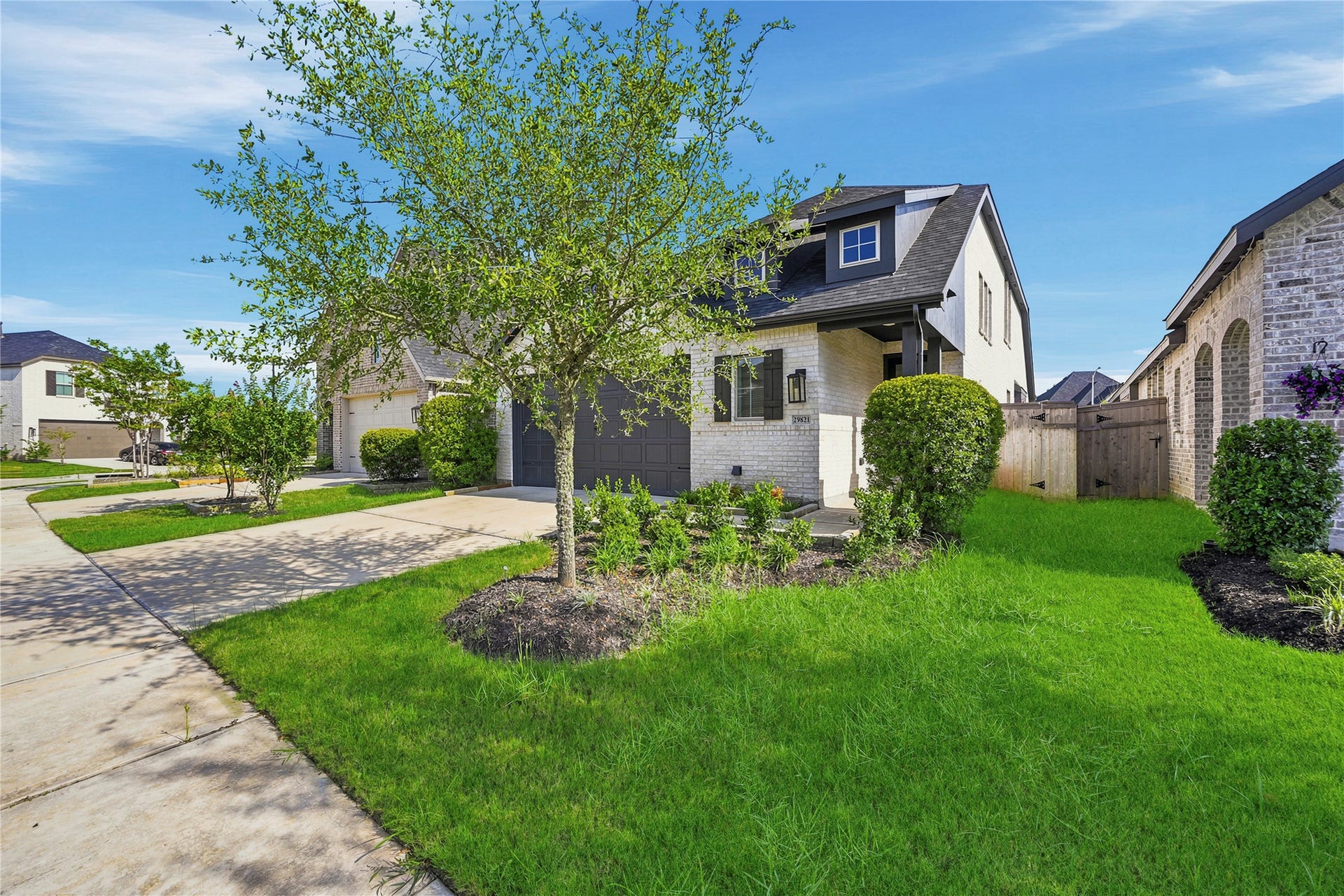 29821 Ellwood Lane, Fulshear, TX 77441 Landscaped front yard with mature trees, lush lawn, and welcoming front entry.
