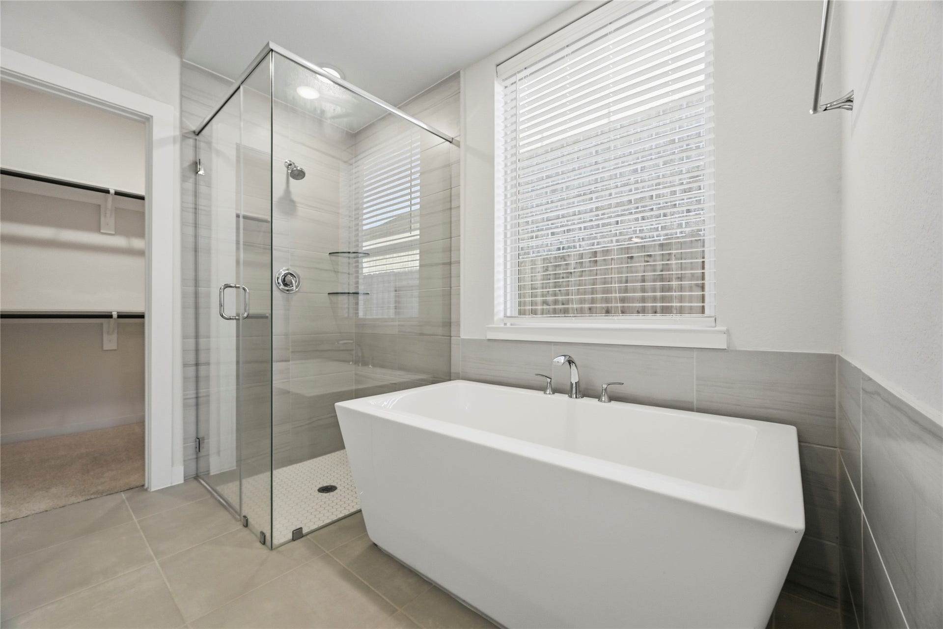 29821 Ellwood Lane, Fulshear, TX 77441 Freestanding soaking tub and oversized frameless glass shower create a spa-inspired primary bathroom retreat.