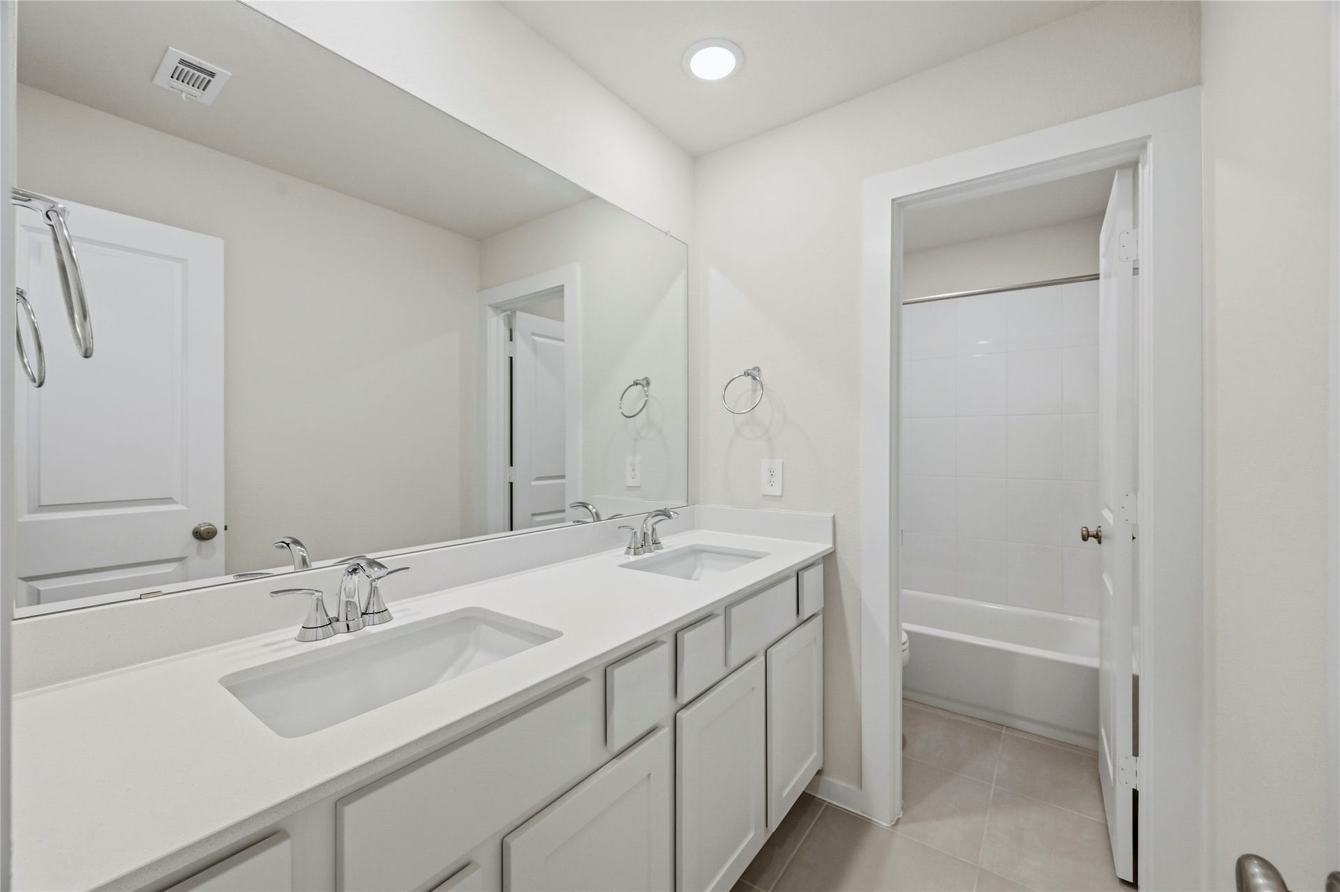 29821 Ellwood Lane, Fulshear, TX 77441 Shared upstairs bathroom featuring dual sinks and a separate tub/shower area.