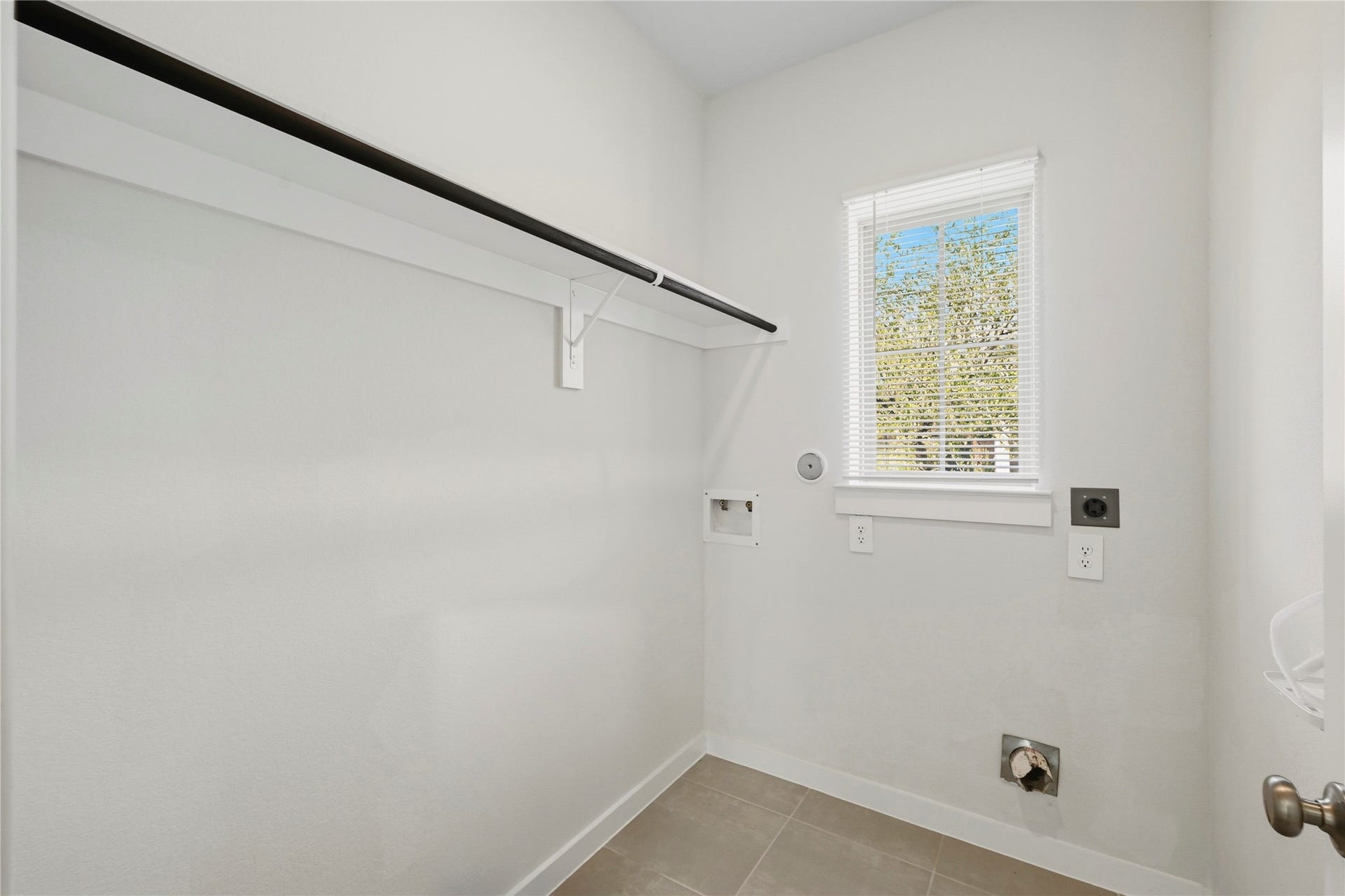 29821 Ellwood Lane, Fulshear, TX 77441 Spacious utility room with built-in shelving and a window for natural light.