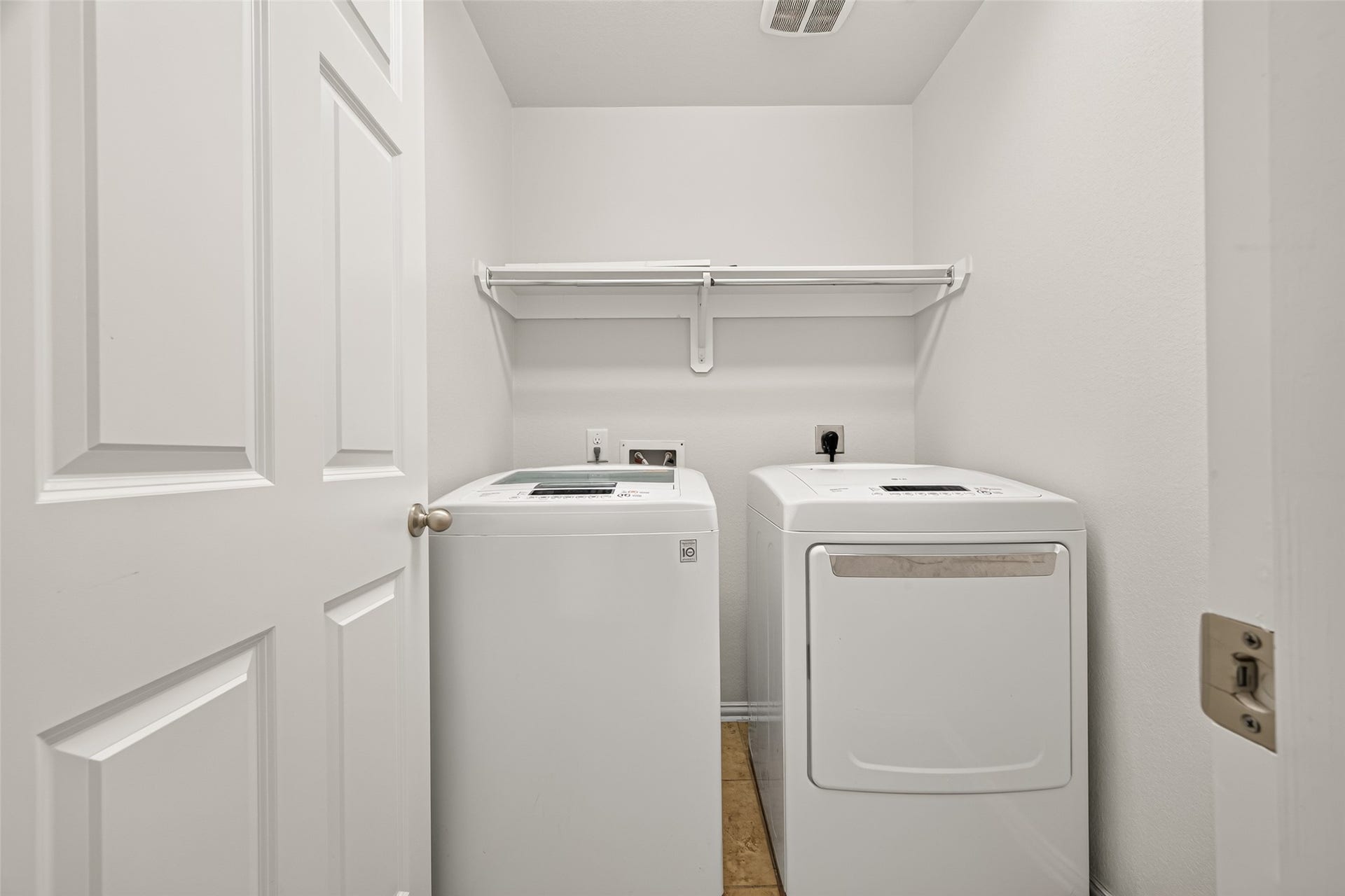 8155 Laughing Falcon Trail, Conroe, TX 77385 Dedicated indoor utility room with space for a full-size washer and dryer, overhead shelving, and hanging storage.