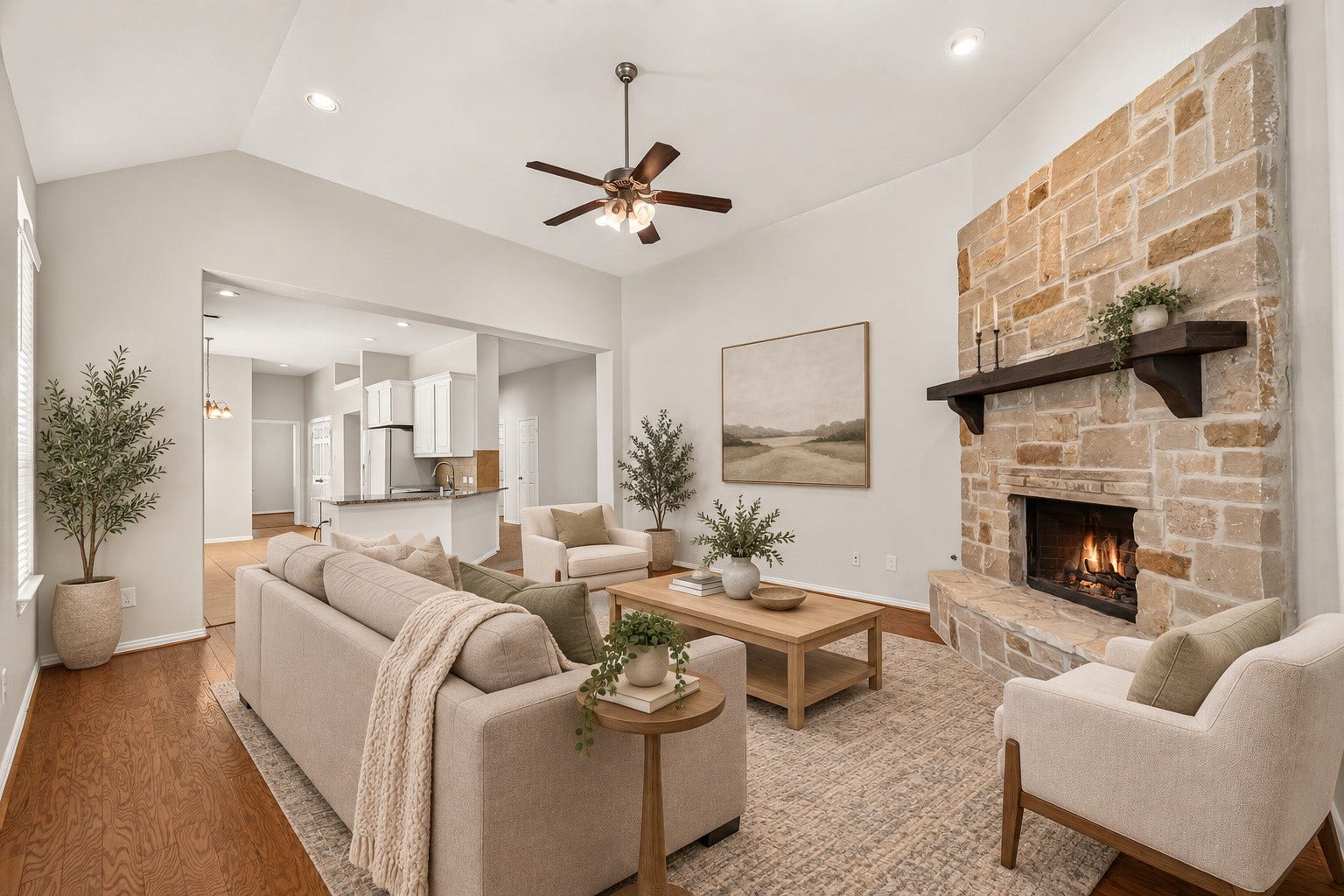 8155 Laughing Falcon Trail, Conroe, TX 77385 Open living room featuring hardwood flooring, a vaulted ceiling, recessed lighting, ceiling fan, and a floor-to-ceiling stone fireplace. Virtually Staged.