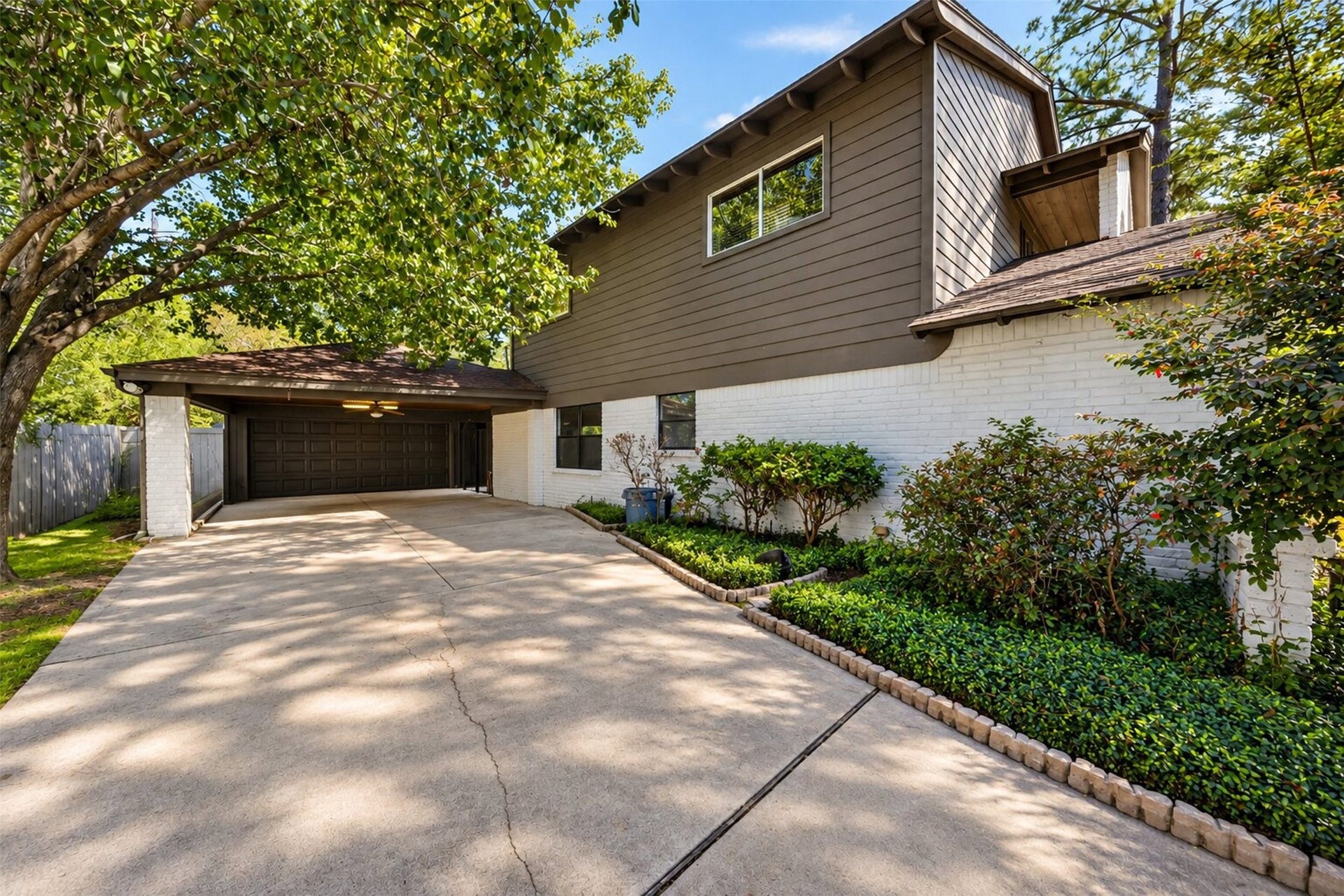 10818 Creektree Drive, Houston, TX 77070 Driveway & Garage: Extended driveway leading to the detached two-car garage, surrounded by mature trees and beautifully maintained landscaping.