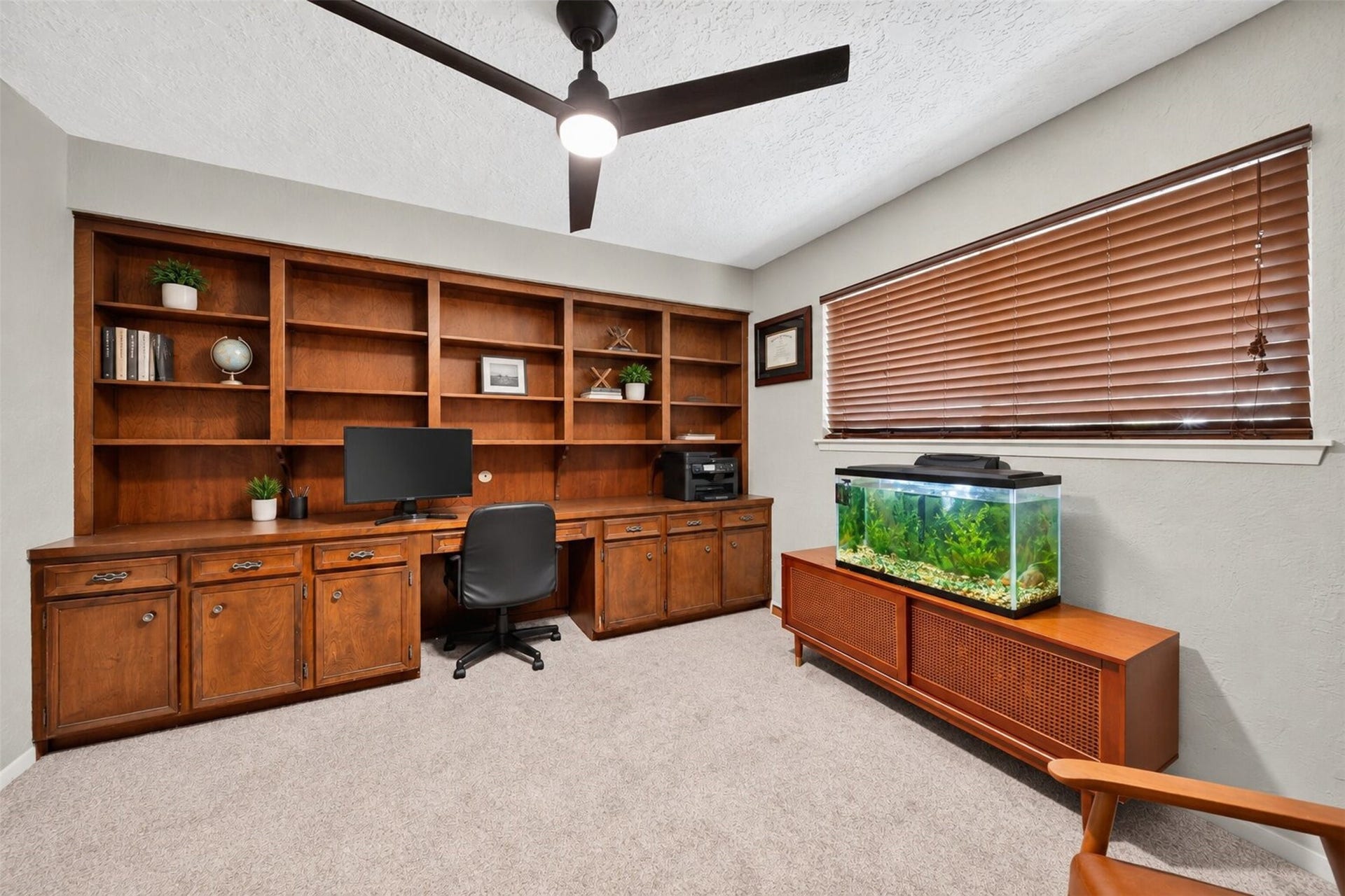 10818 Creektree Drive, Houston, TX 77070 Private Home Office / Study
Dedicated home office featuring expansive built-in wood cabinetry, generous shelving, a spacious workstation, and a ceiling fan. An ideal setting for productivity and organization.