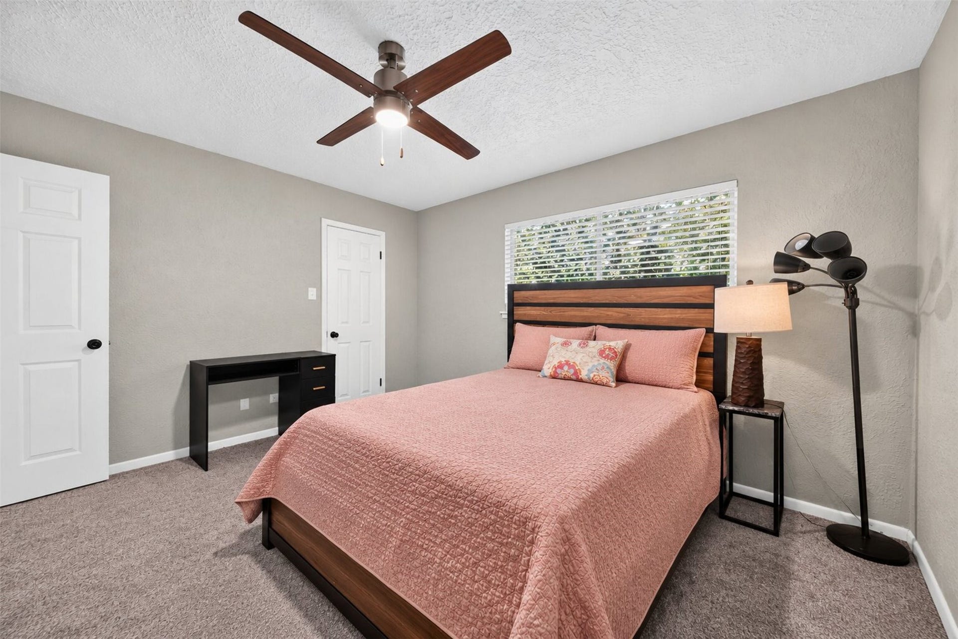 10818 Creektree Drive, Houston, TX 77070 Secondary Bedroom: Spacious secondary bedroom offering neutral finishes, plush carpeting, a ceiling fan, and a large window providing natural light.