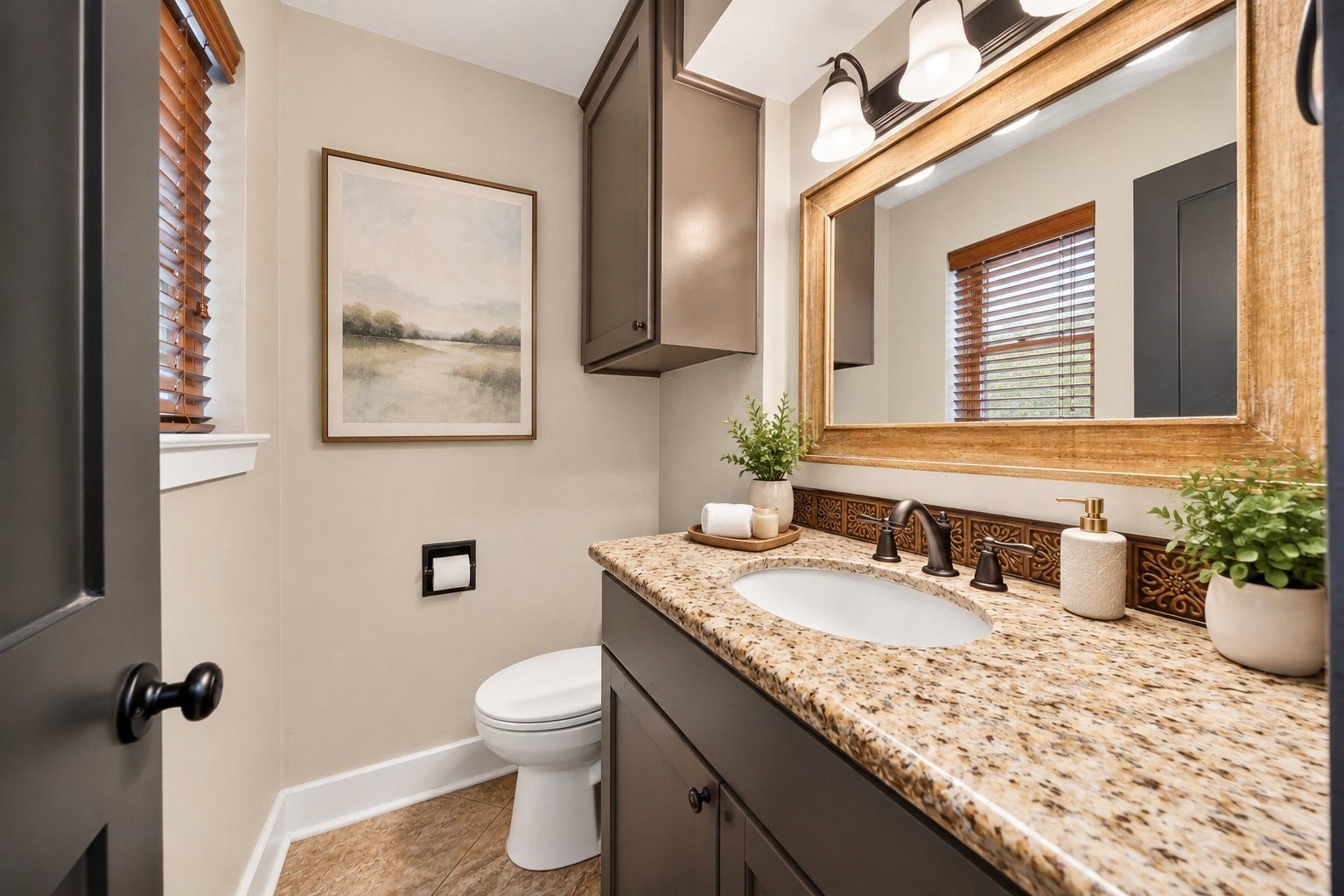 10818 Creektree Drive, Houston, TX 77070 Half Bathroom (Virtually Staged)
Charming powder bathroom featuring a granite countertop, gray vanity cabinetry, decorative tile backsplash, wood-framed mirror, and natural light from the window.