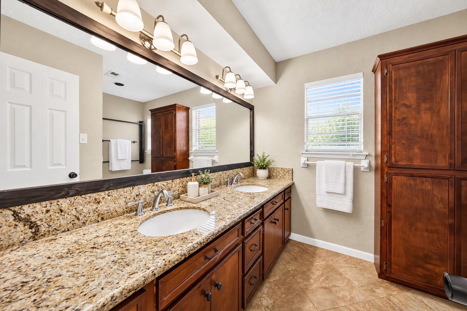 10818 Creektree Drive, Houston, TX 77070 Secondary Bathroom
Spacious primary bathroom featuring an expansive double-sink vanity, granite countertops, rich wood cabinetry, oversized framed mirror, and abundant storage. Natural light creates a bright, welcoming atmosphere.