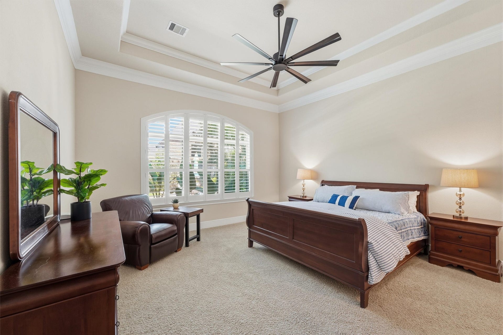 51 S Fremont Ridge Loop, Spring, TX 77389 The owners suite offers a serene retreat with a tray ceiling, classic crown molding, and a large arched window with plantation shutters.