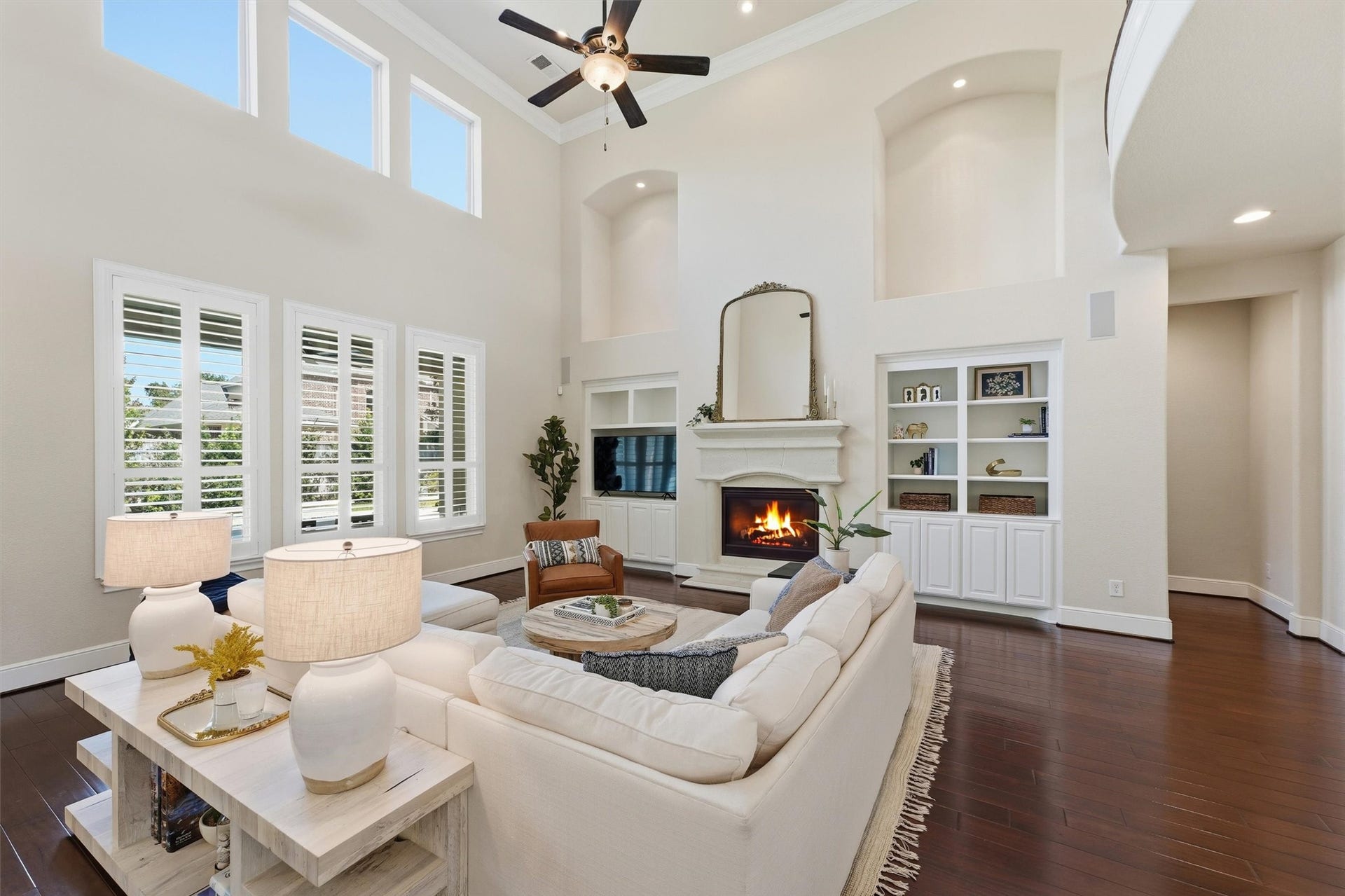 51 S Fremont Ridge Loop, Spring, TX 77389 The two-story family room features abundant natural light, a welcoming fireplace, and custom built-ins, creating an inviting place to relax and gather.