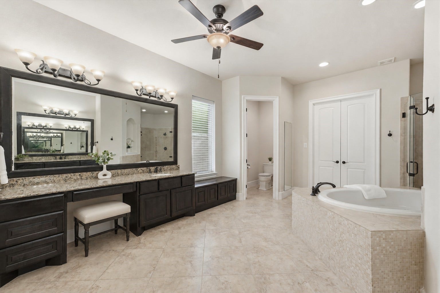 51 S Fremont Ridge Loop, Spring, TX 77389 The owners ensuite bath features two large vanities, including this one with a seated vanity area, generous storage, and a nearby dressing bench.