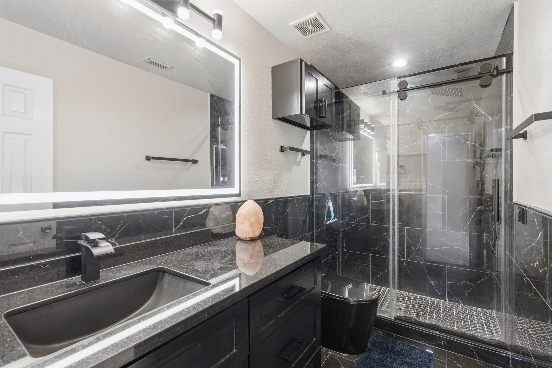 19302 Christine Crossing Drive, Richmond, TX 77407 Completely remodeled, the upstairs bathroom offers a sleek vanity and a glass-enclosed walk-in shower.