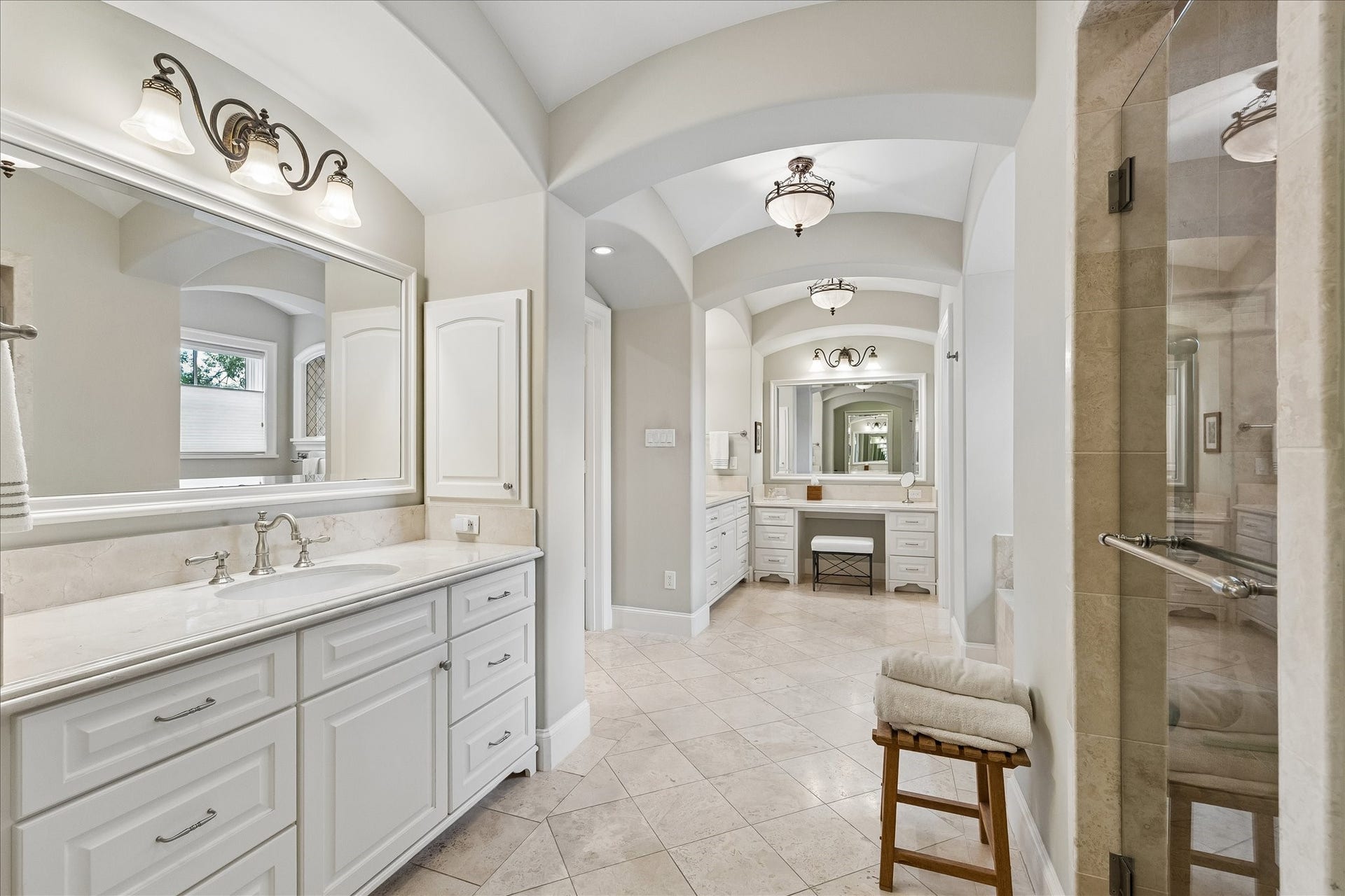 Spa-like primary bath with dual sinks, separate shower, soaking tub and vanity area.